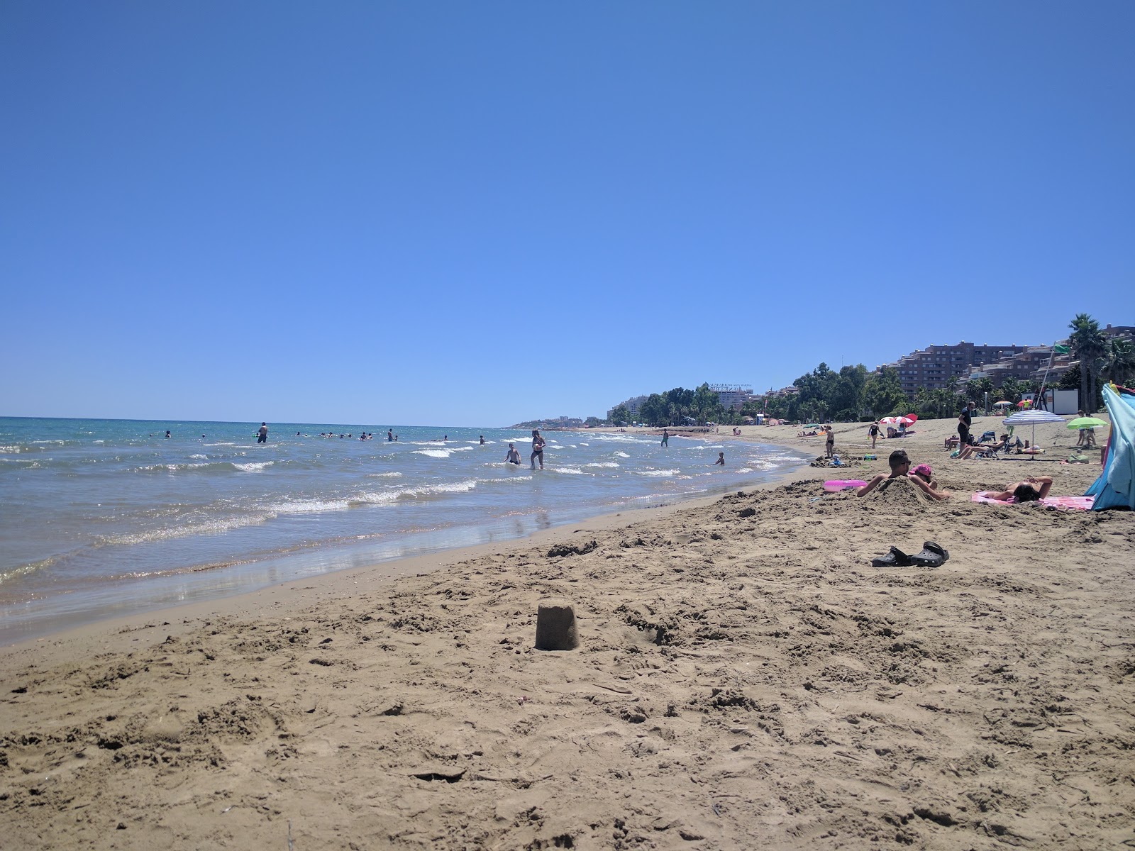 Foto van Playa de les Amplaries met groen water oppervlakte