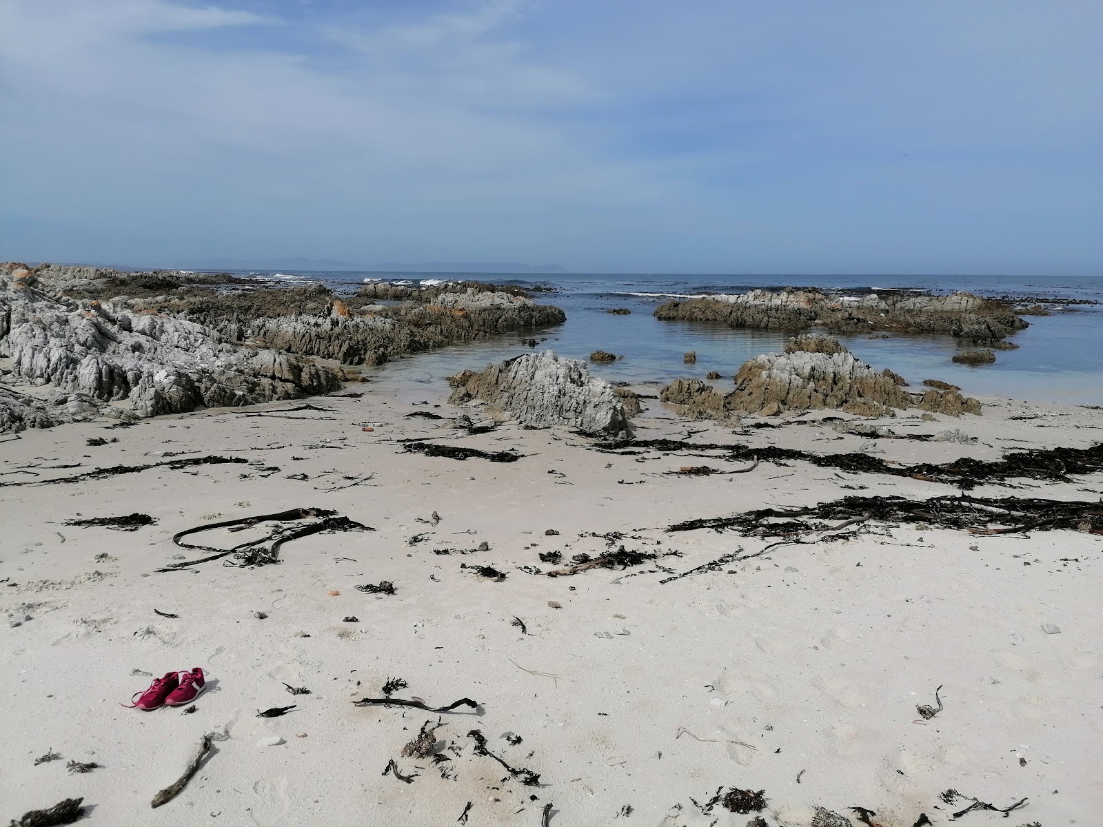 Fotografie cu Breakfast Bay beach cu o suprafață de nisip strălucitor și pietre