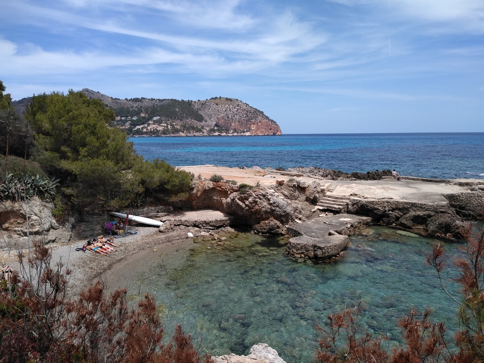 Φωτογραφία του Cala Rotja με γκρίζα άμμο και βράχια επιφάνεια