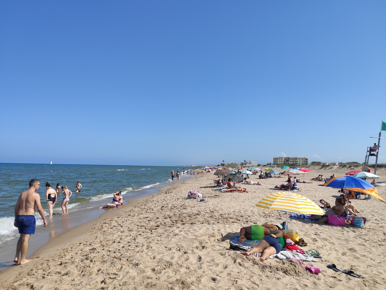 Foto av Platja la Garrofera med grönt vatten yta