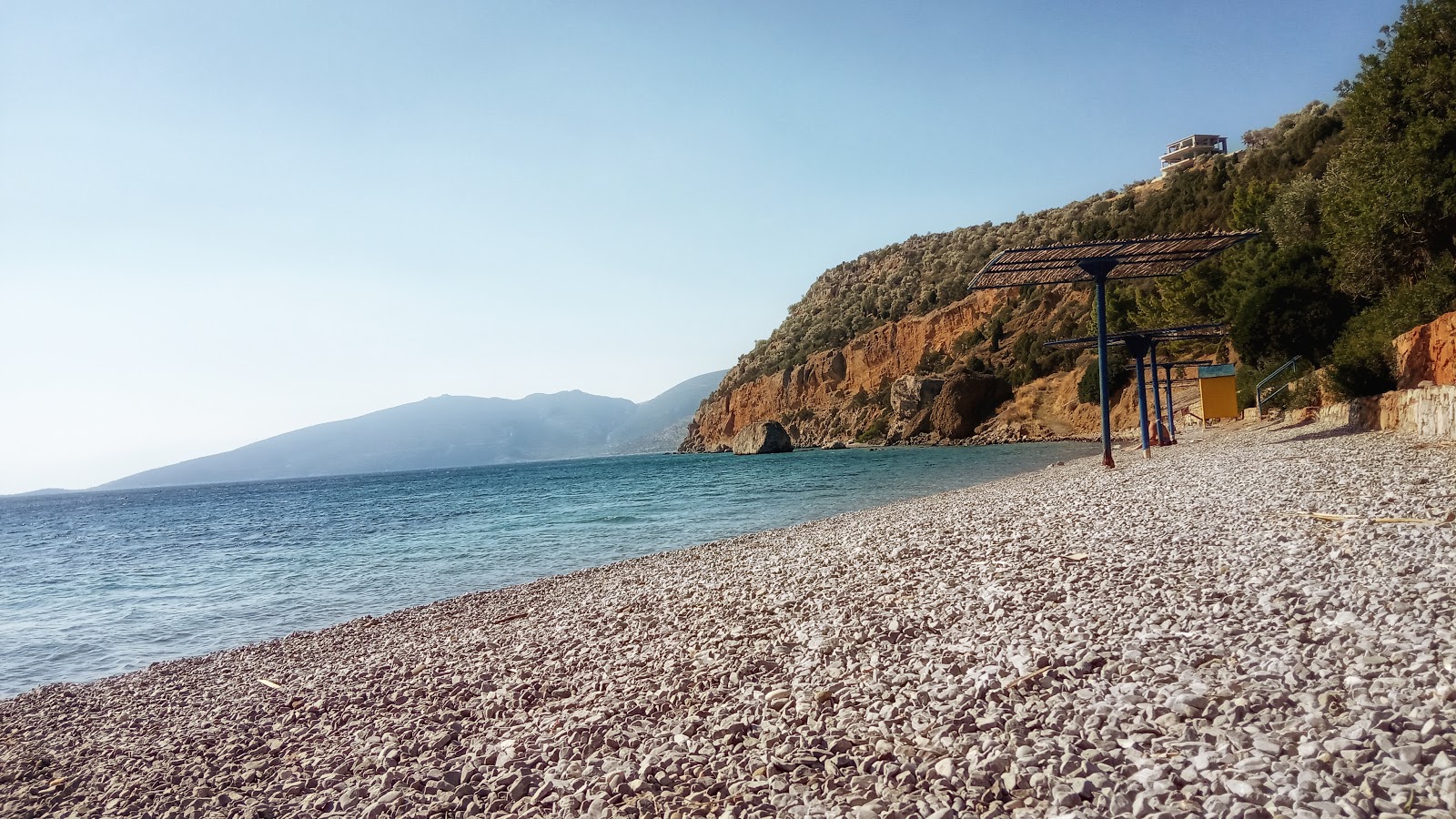 Fotografie cu Agios Isidoros beach sprijinit de stânci