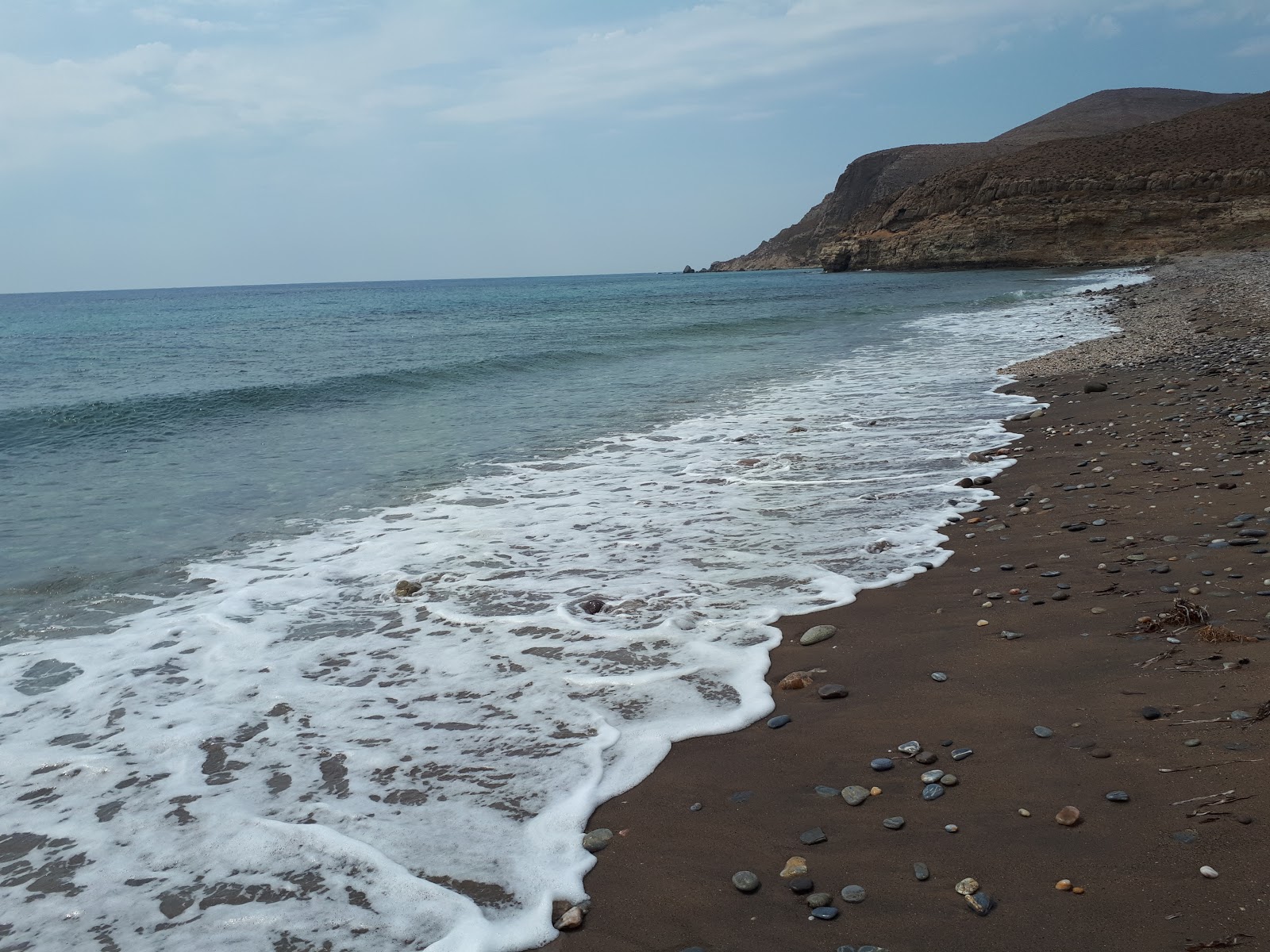 Valokuva Ftelio beachista. pinnalla kevyt hiekka ja kivi:n kanssa