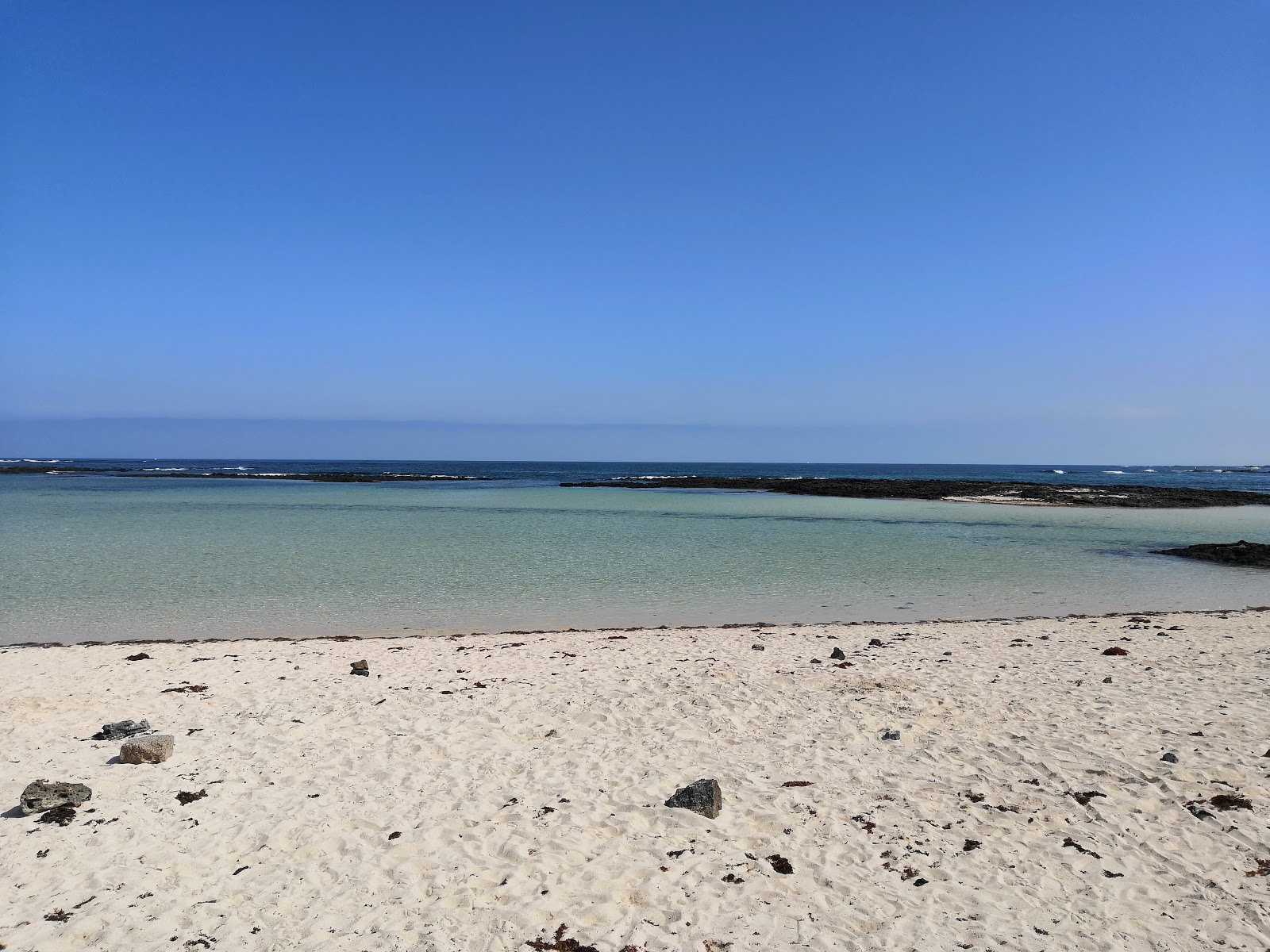 Foto de Playa El Charcón con arena beige y rocas superficie