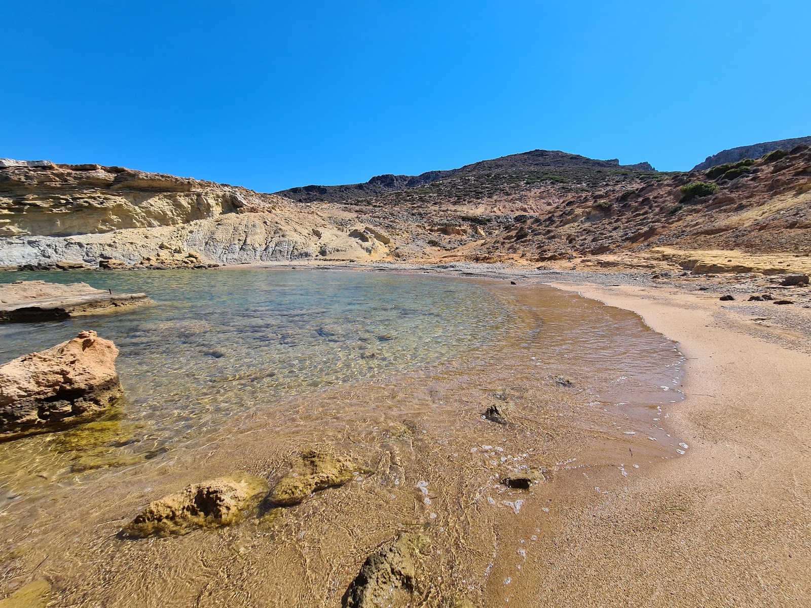 Clay beach的照片 带有棕色沙和岩石表面