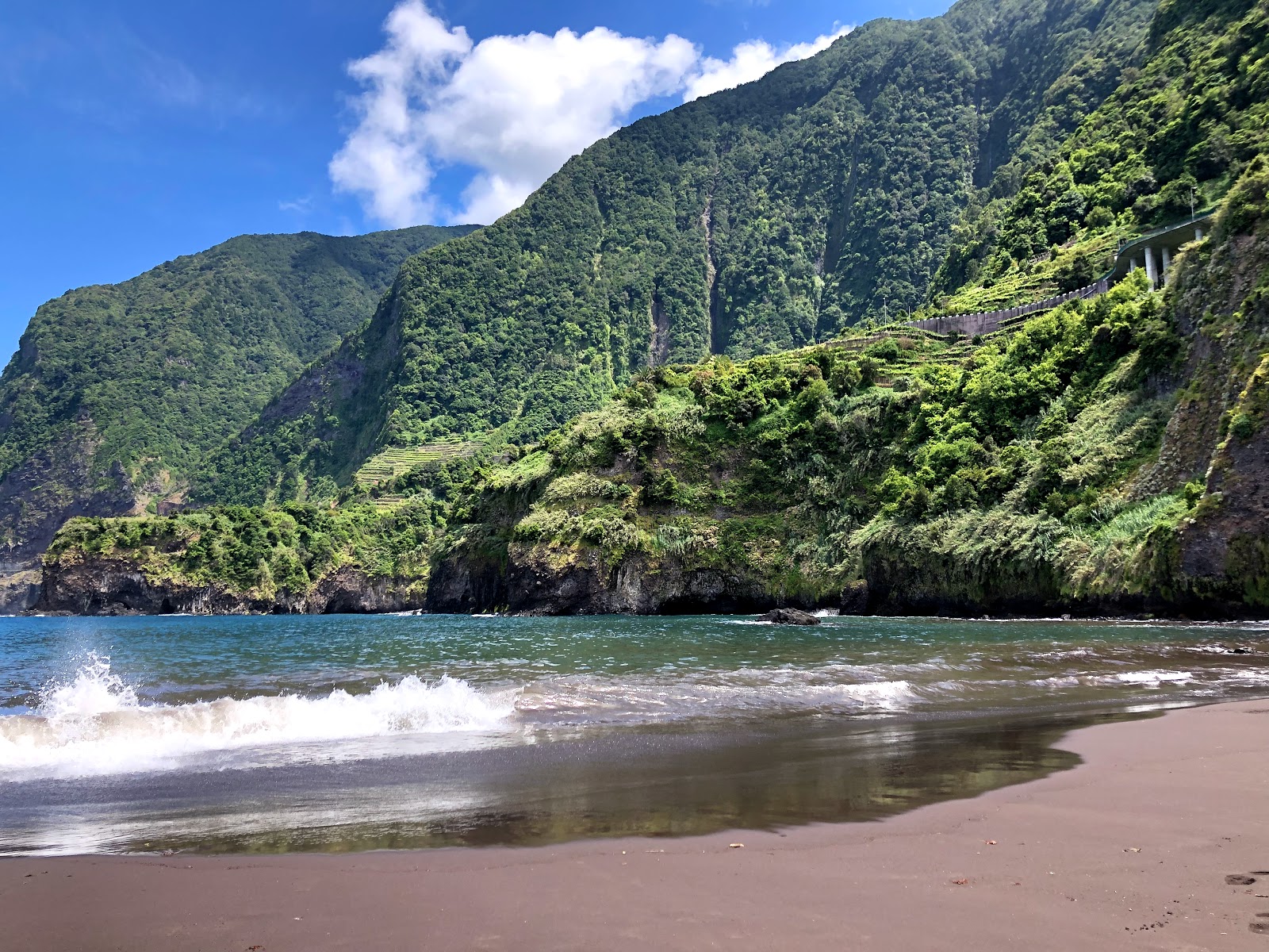 Praia do Porto do Seixal'in fotoğrafı kahverengi kum yüzey ile