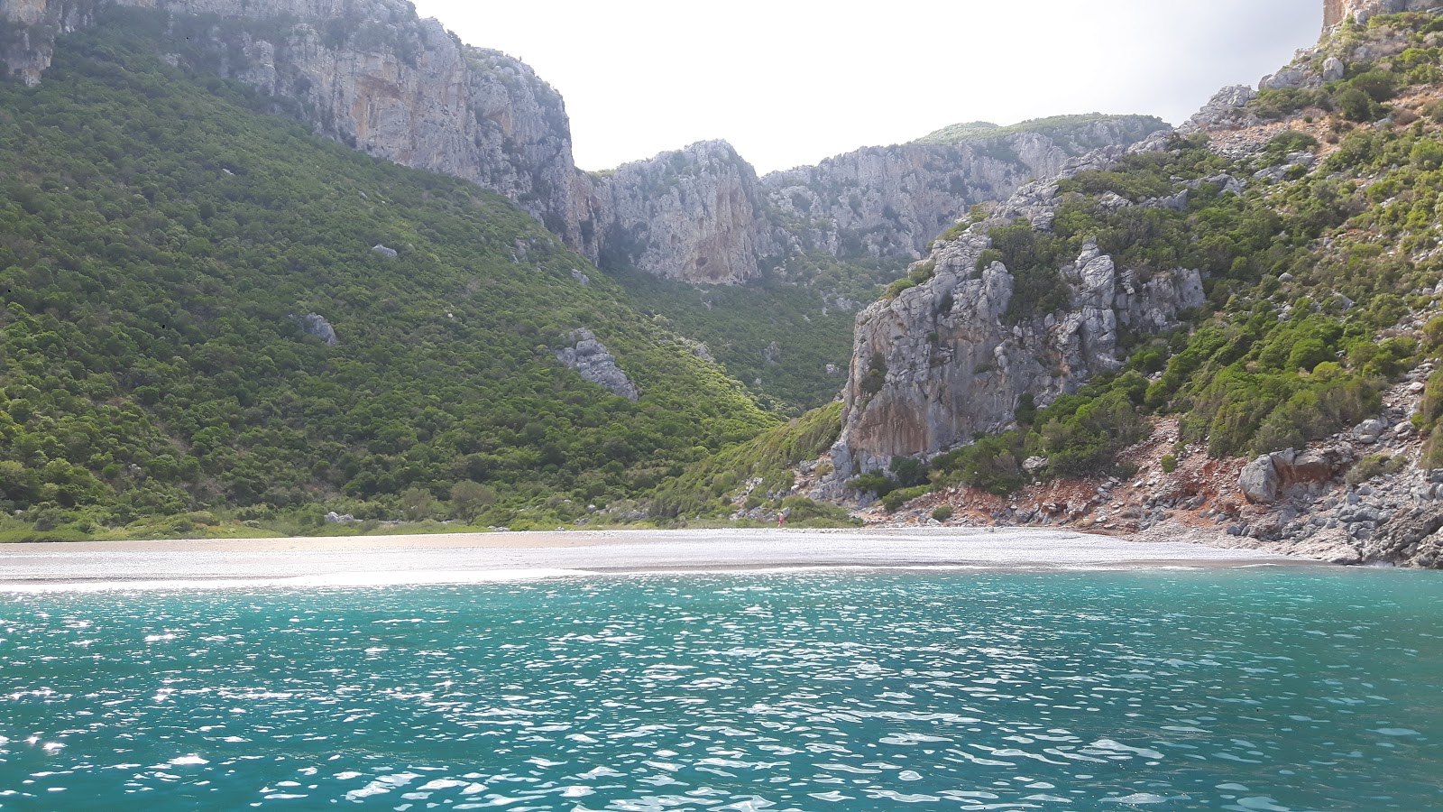 Photo de Damos beach protégé par des falaises