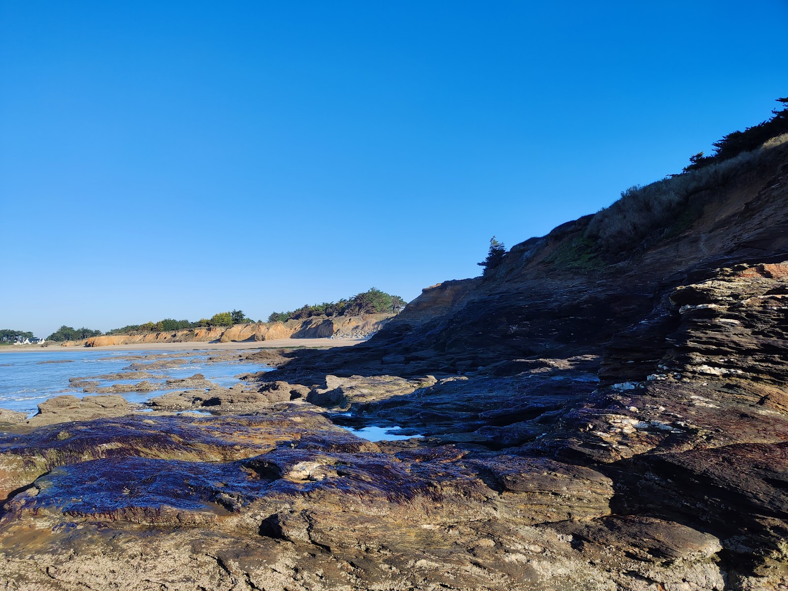 Foto von Plage de Goulumer umgeben von Bergen
