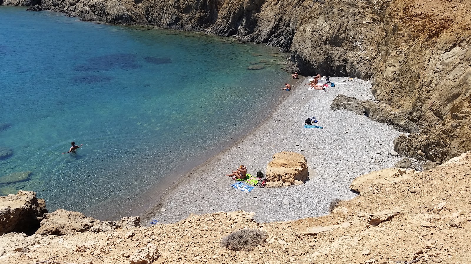 Zdjęcie Plakes beach z powierzchnią małe beżowe kamyki
