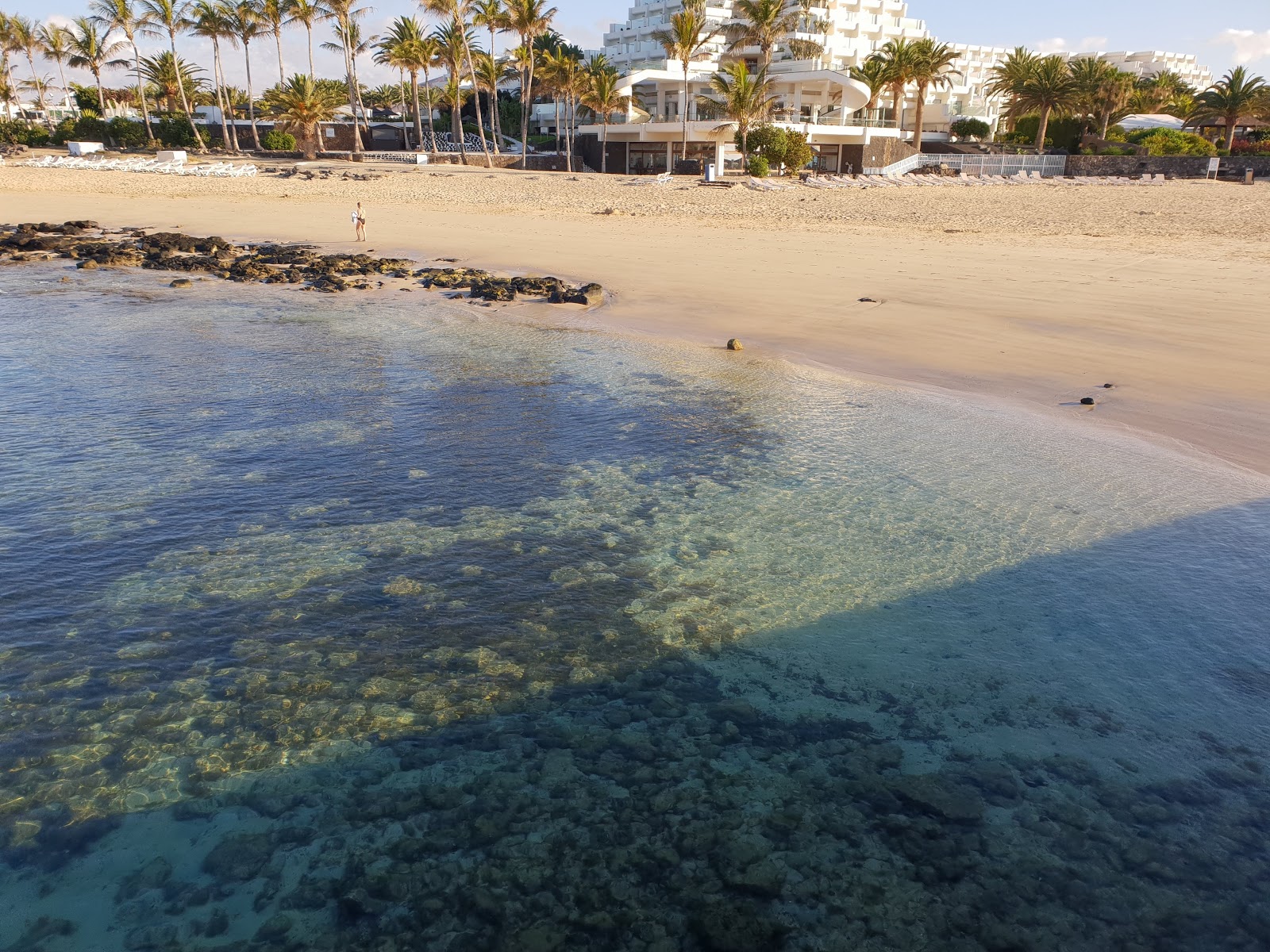 Photo de Playa de los Charcos avec l'eau vert clair de surface