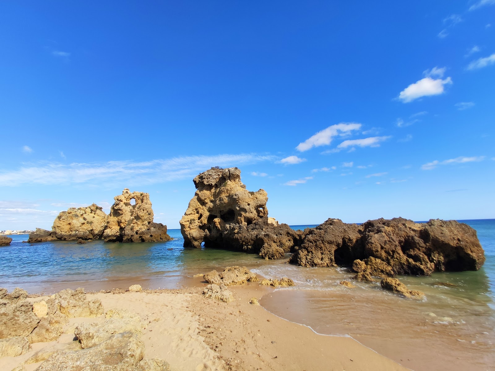 Foto von Praia dos Arrifes umgeben von Bergen