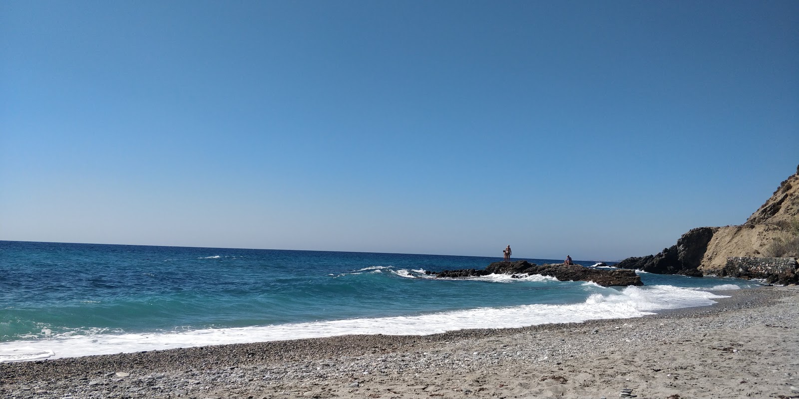 Fotografie cu Playa de las Alberquillas cu o suprafață de pietricel alb fin