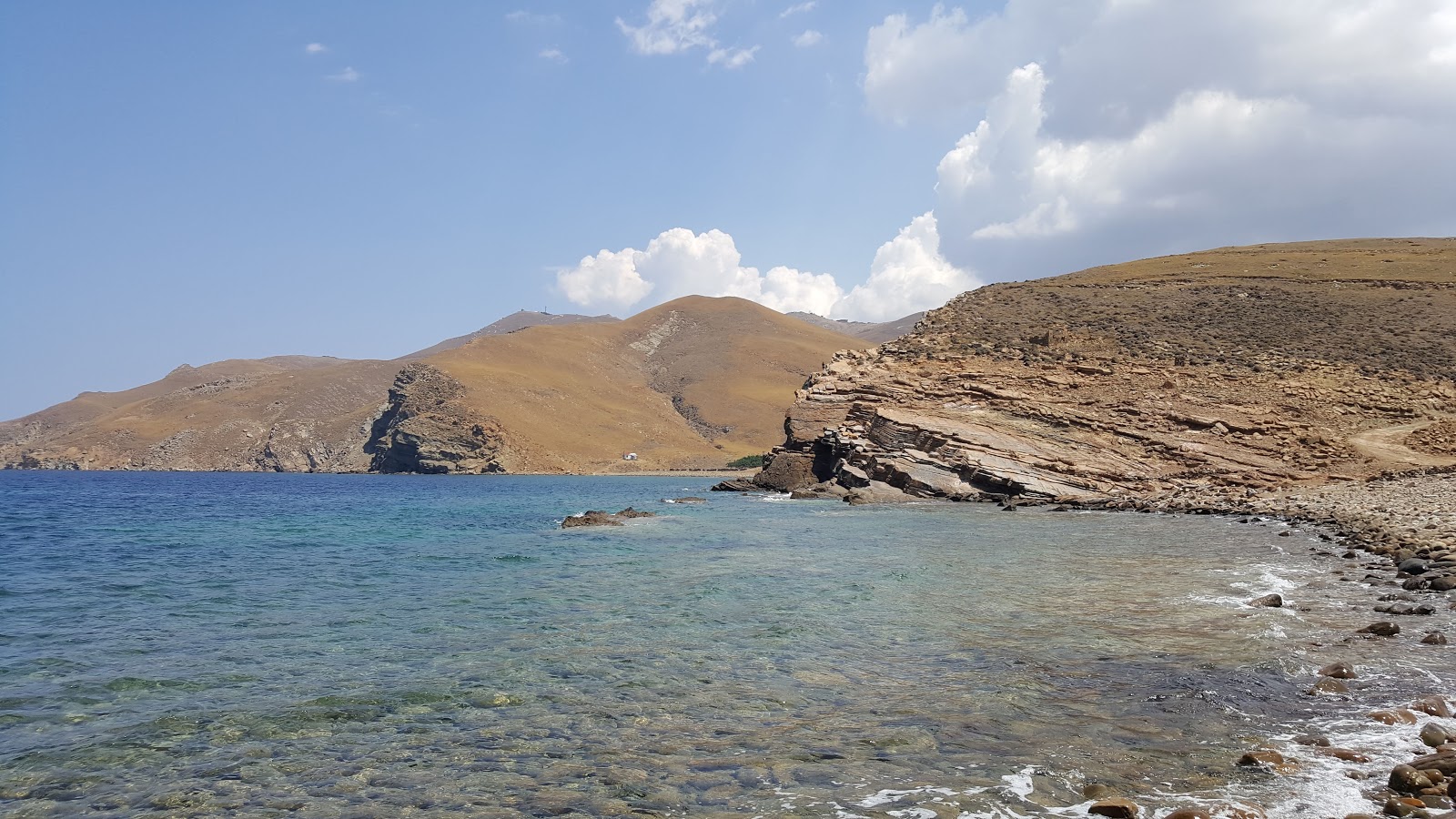 Foto af Mourtzeflos beach bakket op af klipperne