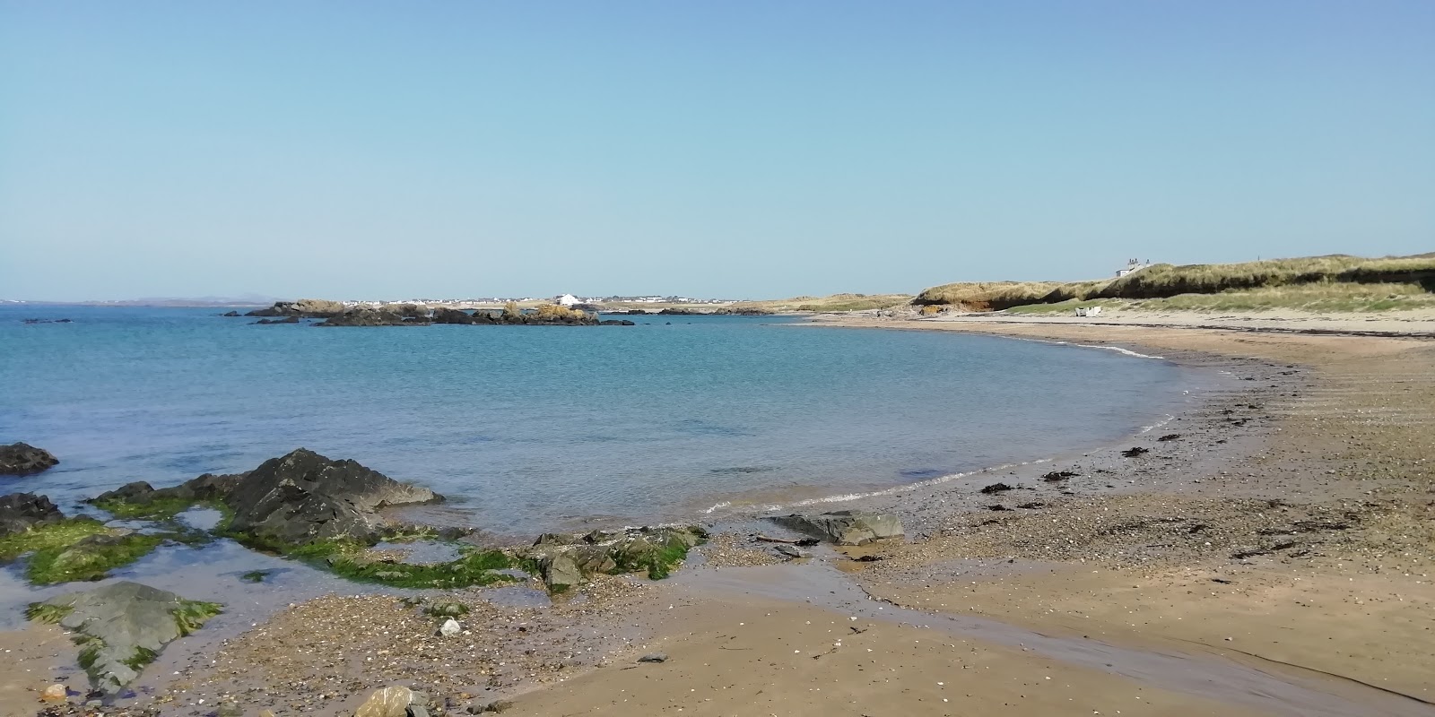 Foto av Porth Tyn Tywyn med harmaa hiekka ja kivi yta