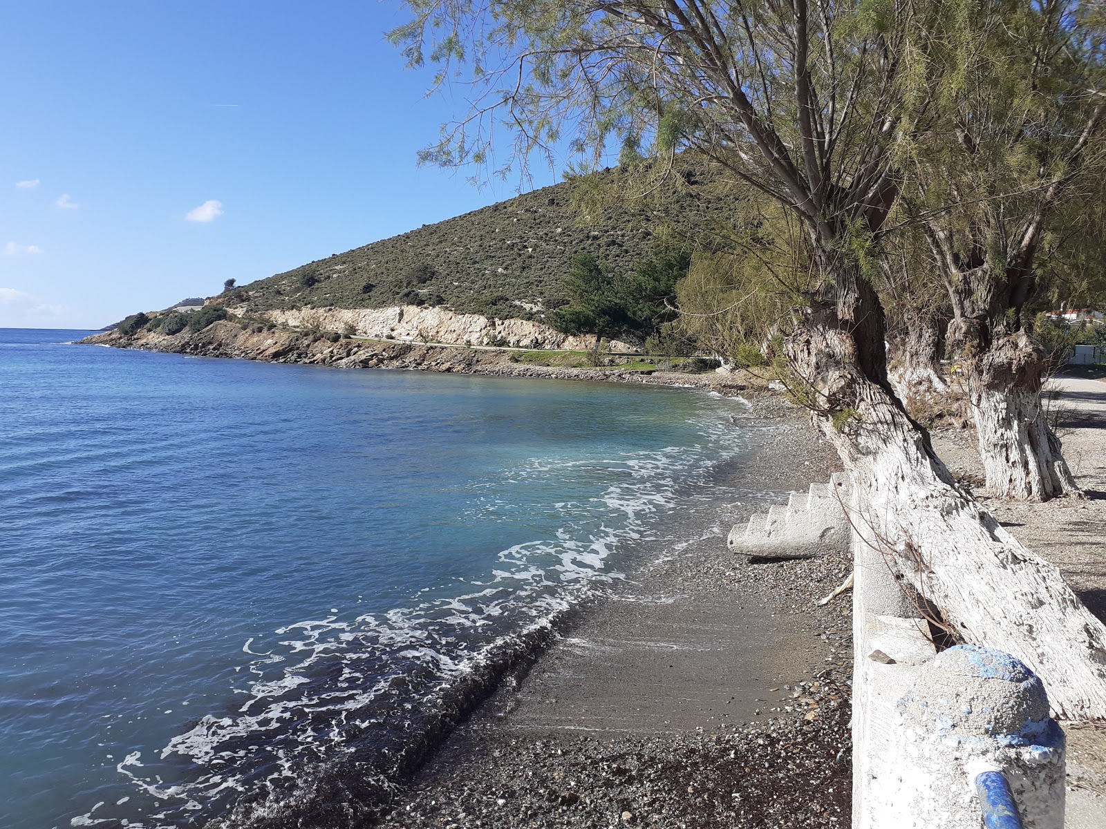 Photo de Tis Popis beach avec sable gris avec roches de surface