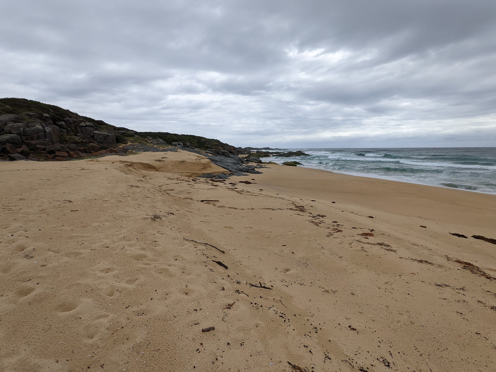Foto av Coila Beach med beige sand yta