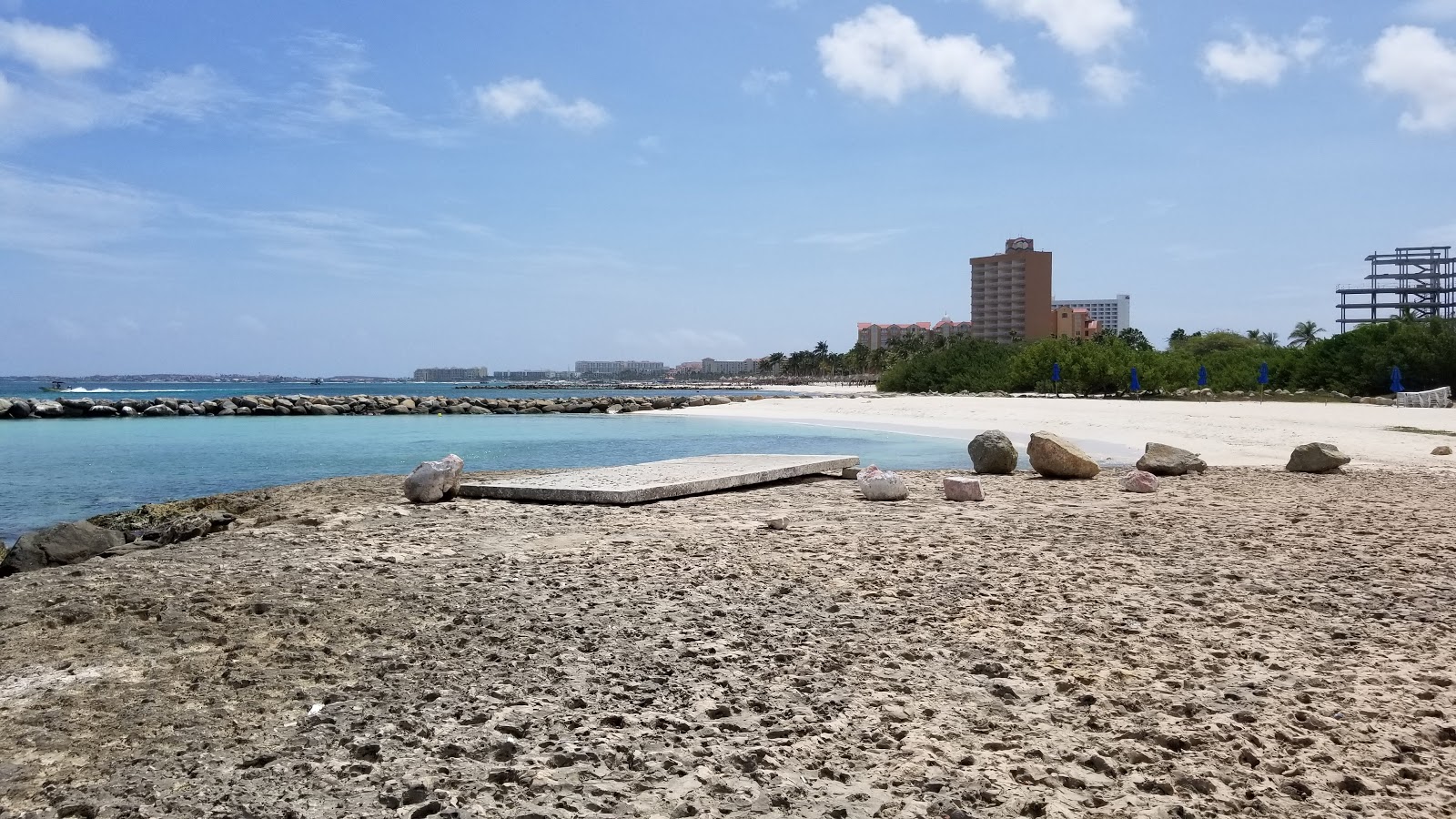 Photo of Blue Residences beach with gray sand &  rocks surface