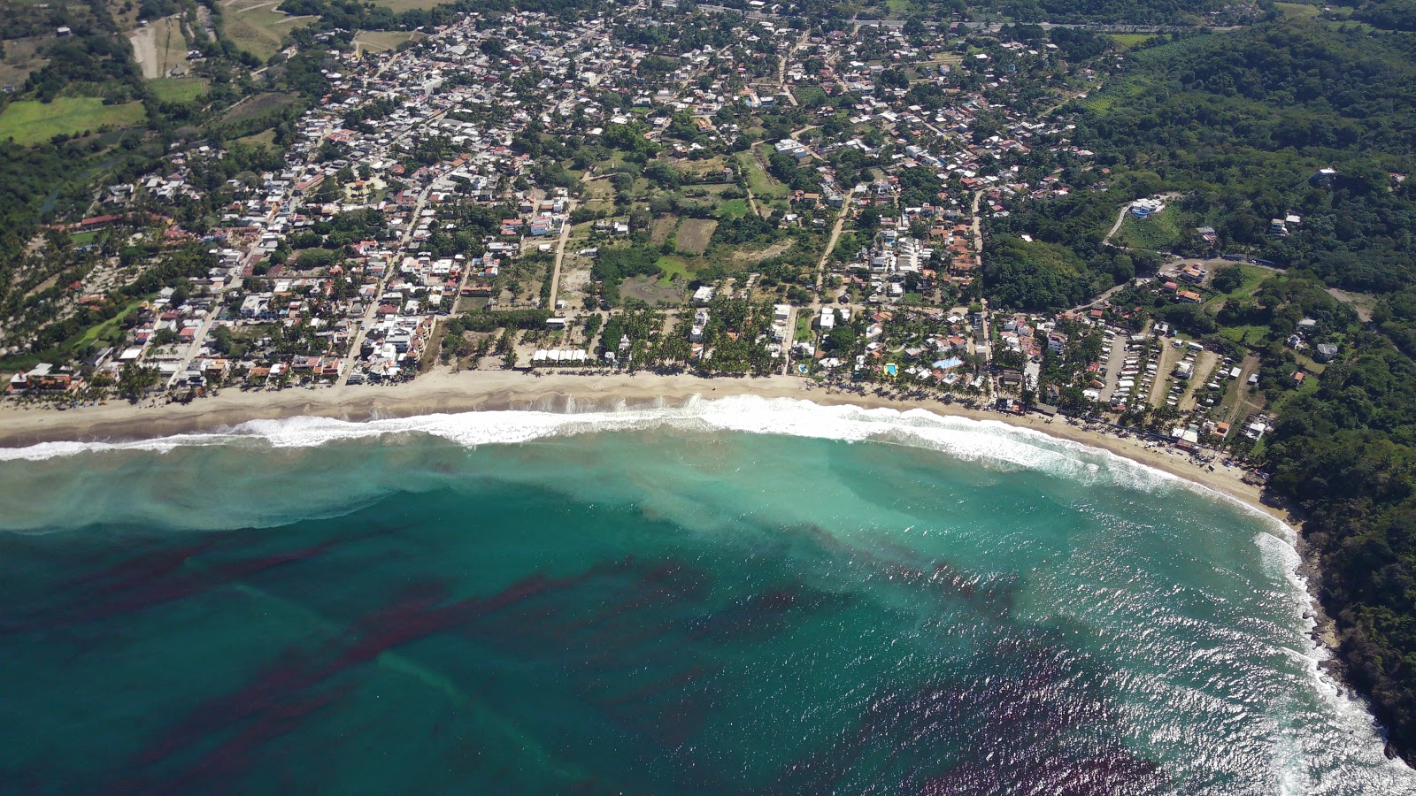 Foto af Lo de Marcos beach bakket op af klipperne
