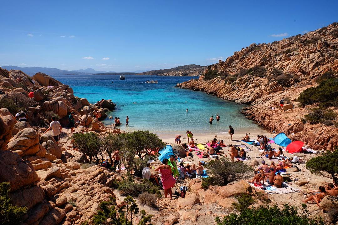 Spiaggia di Cala Coticcio
'in fotoğrafı dağlarla çevrili