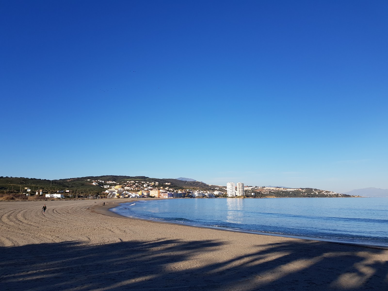 Valokuva Playa de Torreguadiaroista. pinnalla harmaa hiekka:n kanssa