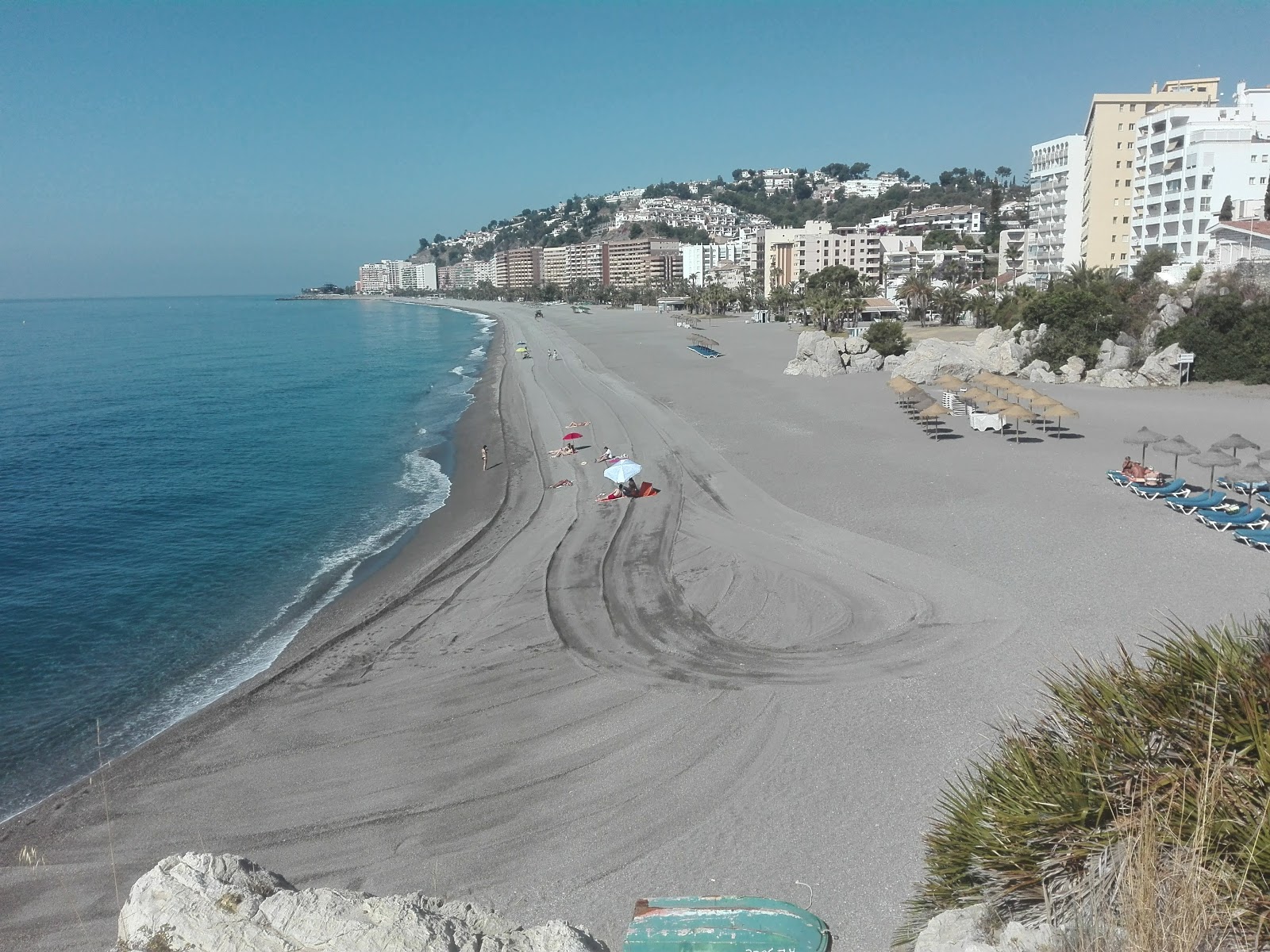 Foto af Playa de Velilla med grå fin sten overflade