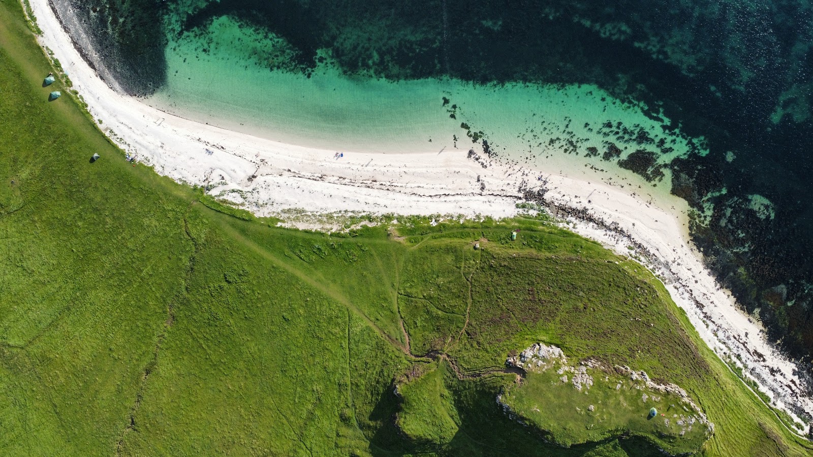 Foto af Coral Beach bakket op af klipperne