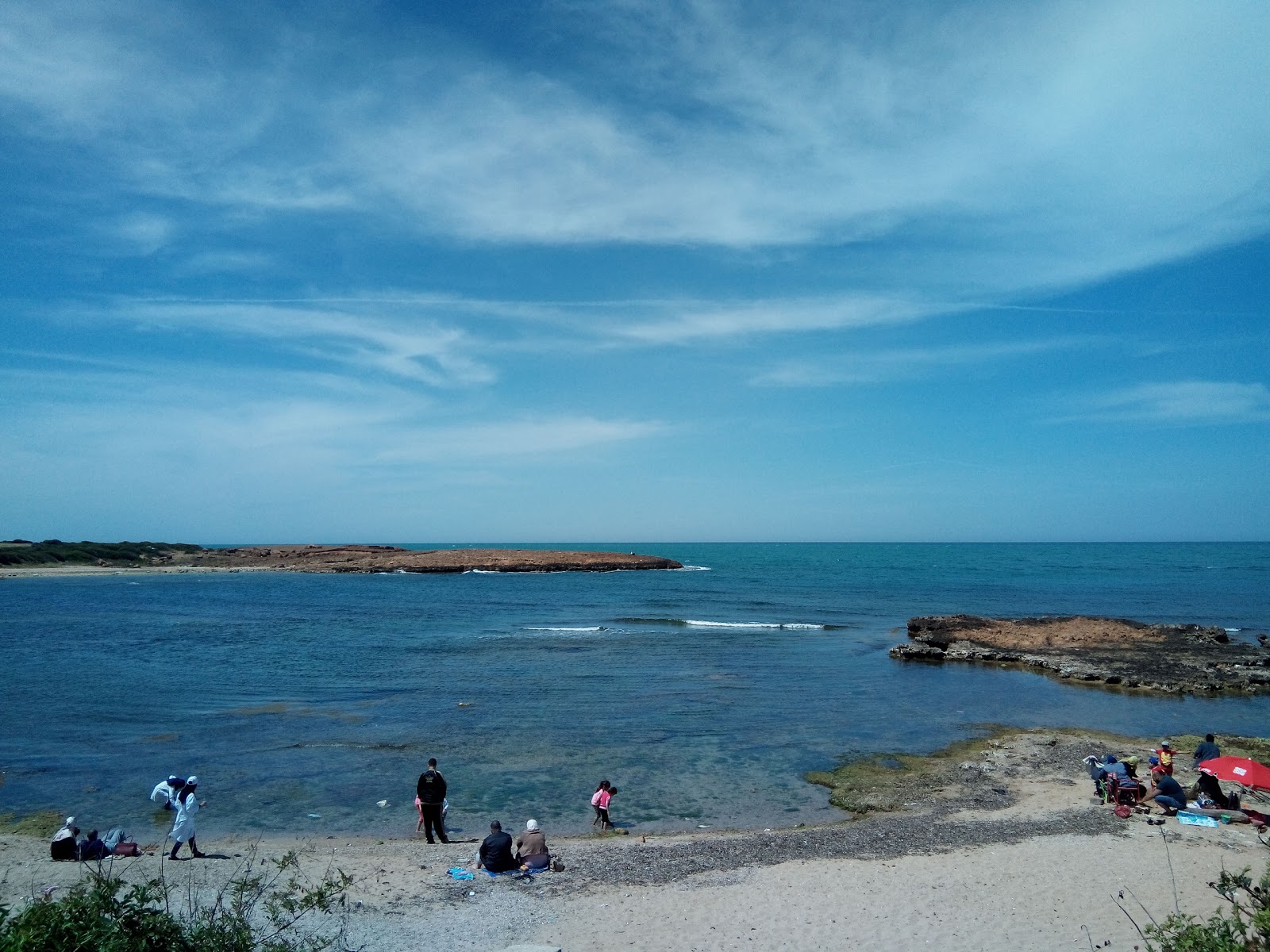 Fotografie cu Plage De Kouali cu o suprafață de nisip strălucitor și pietre