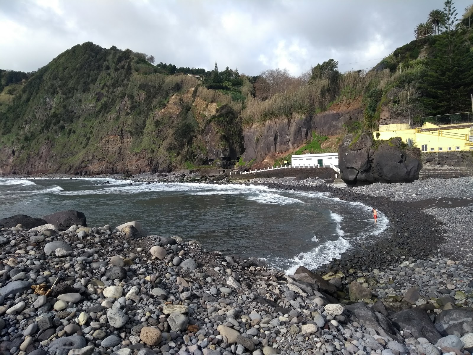 Foto von Povoacao Beach von Klippen umgeben
