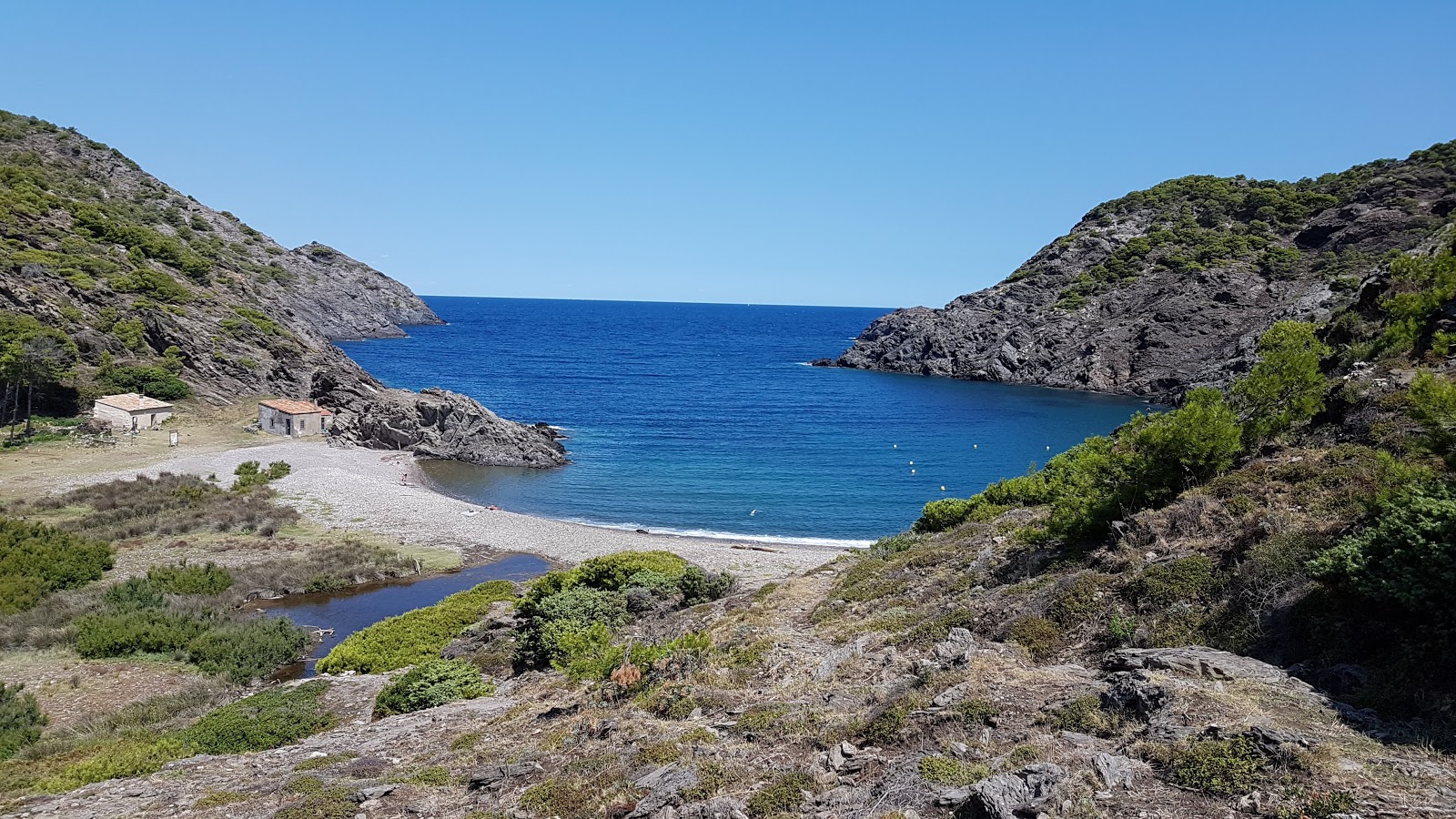 Foto di Cala Tavallera con una superficie del piccoli ciottoli beige