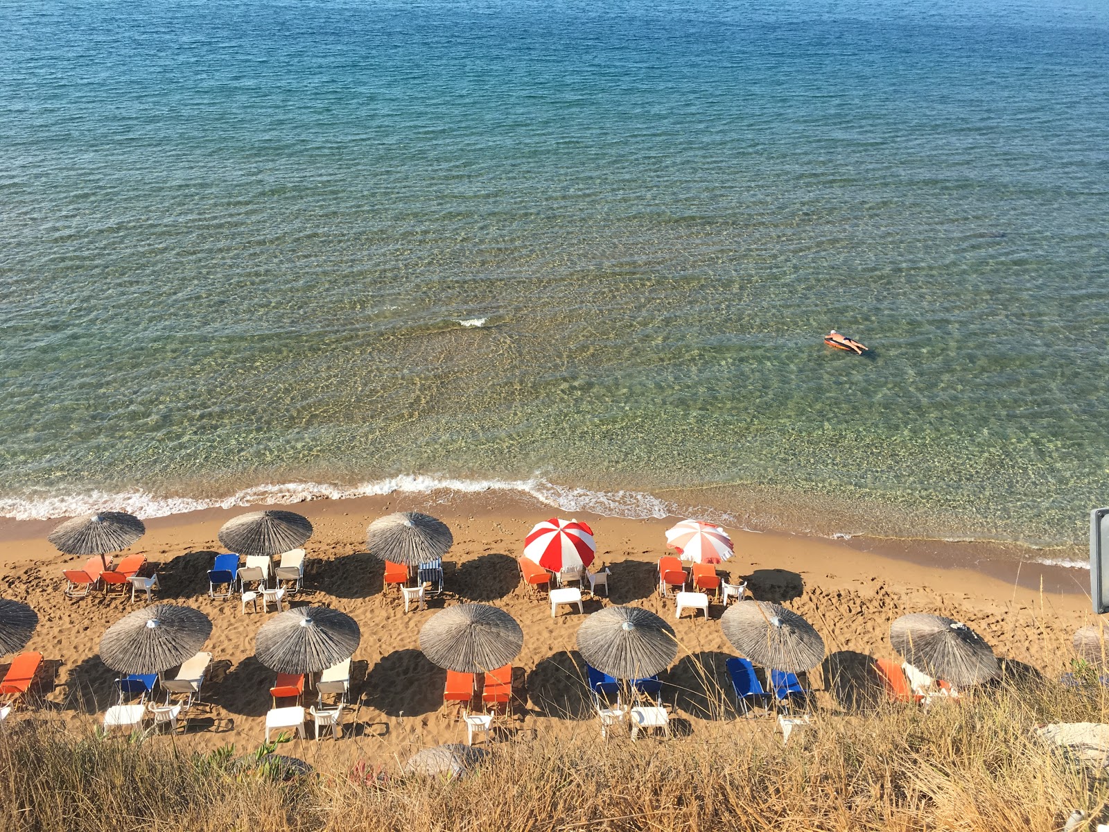 Agios Georgios beach的照片 带有碧绿色纯水表面