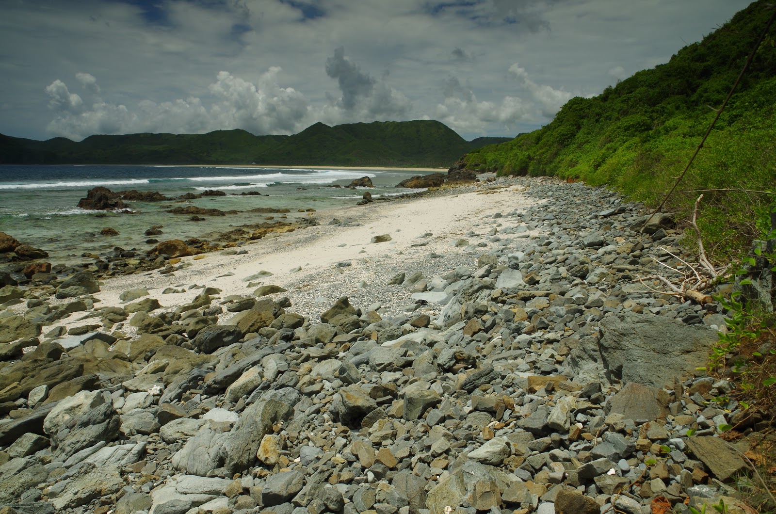 Foto di Batu Bereng Beach con una superficie del sabbia luminosa e rocce