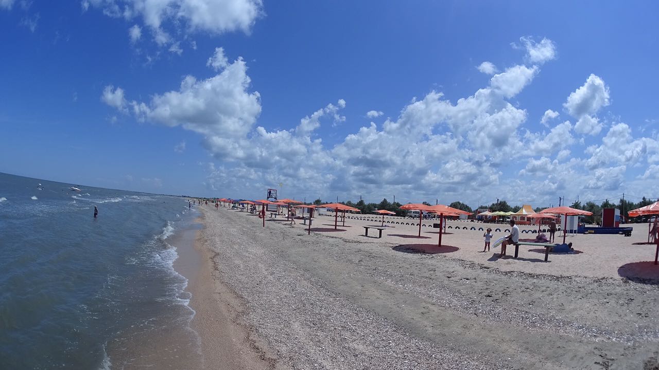 Oazis Beach的照片 带有米色贝壳沙子表面