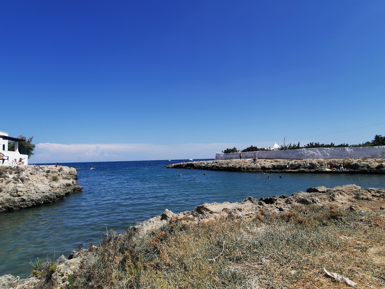 Porto Contessa Beach'in fotoğrafı dağlarla çevrili