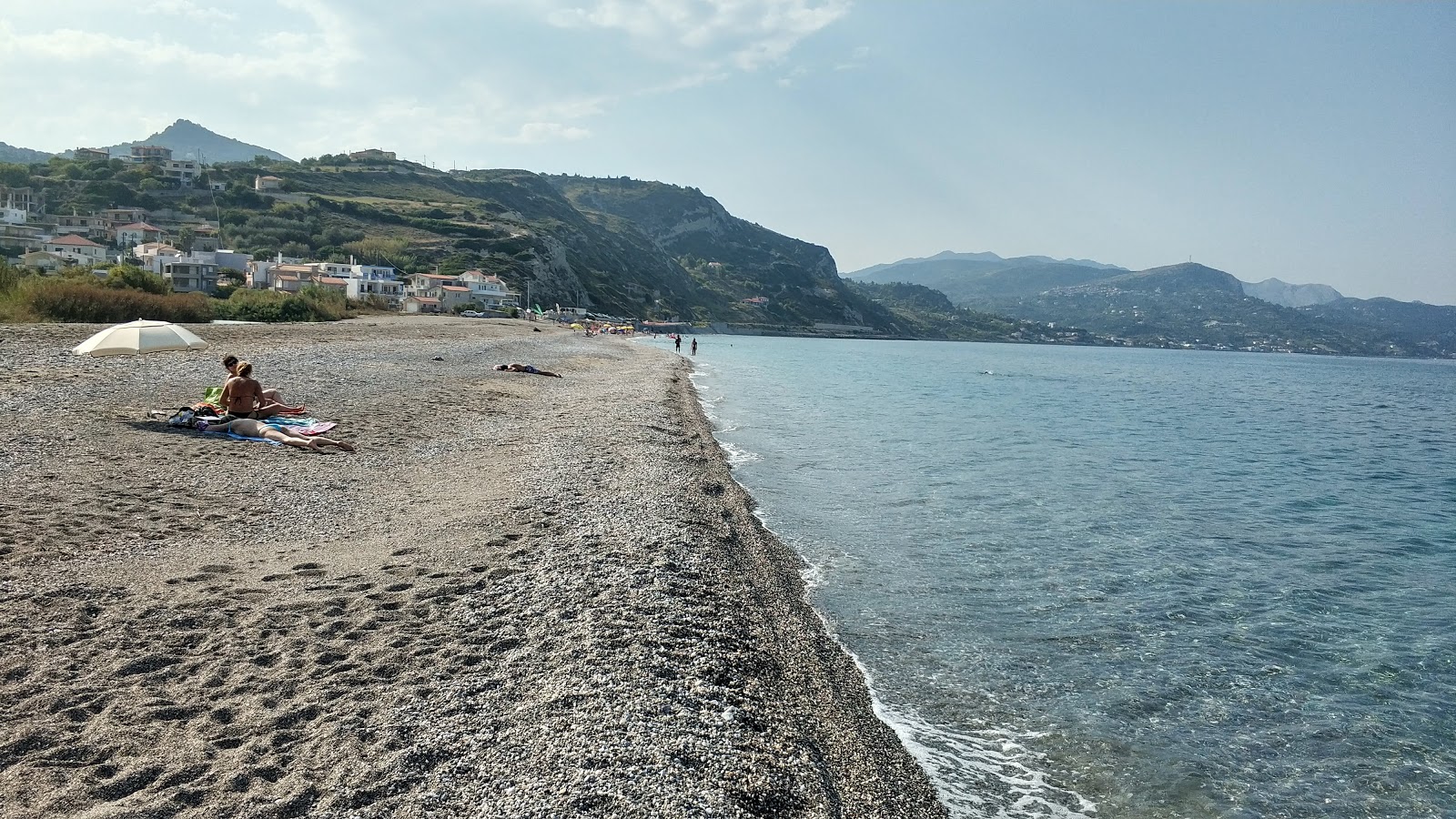 Foto von Stomi beach von Klippen umgeben