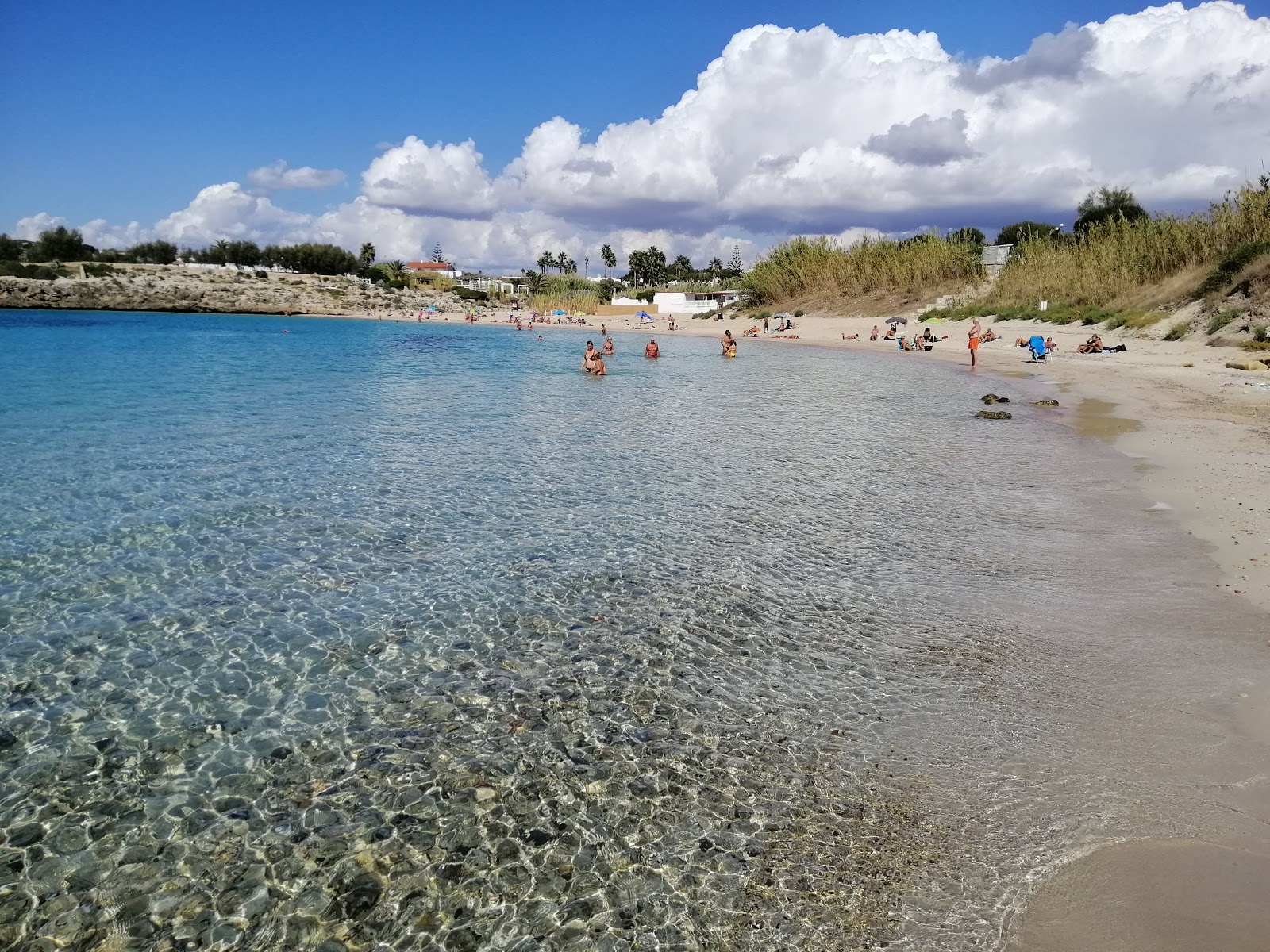Fotografie cu Plaja Canneto cu o suprafață de apă pură albastră