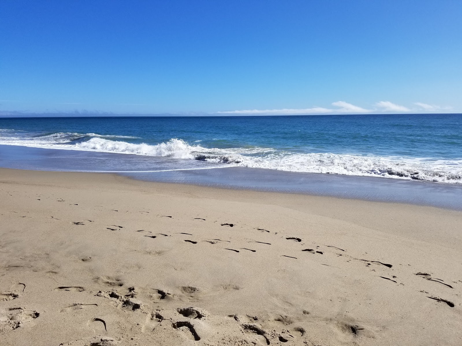 Mugu beach的照片 带有碧绿色水表面