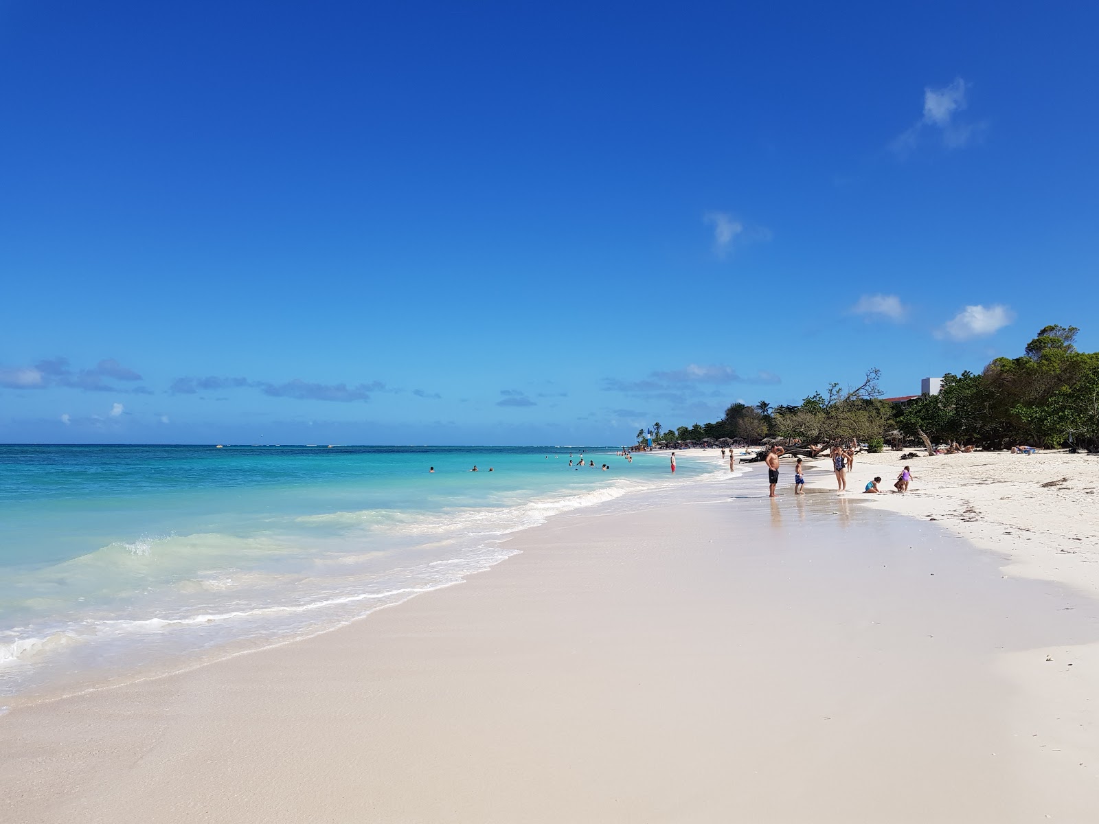 Foto de Playa Guardalavaca con arena fina blanca superficie