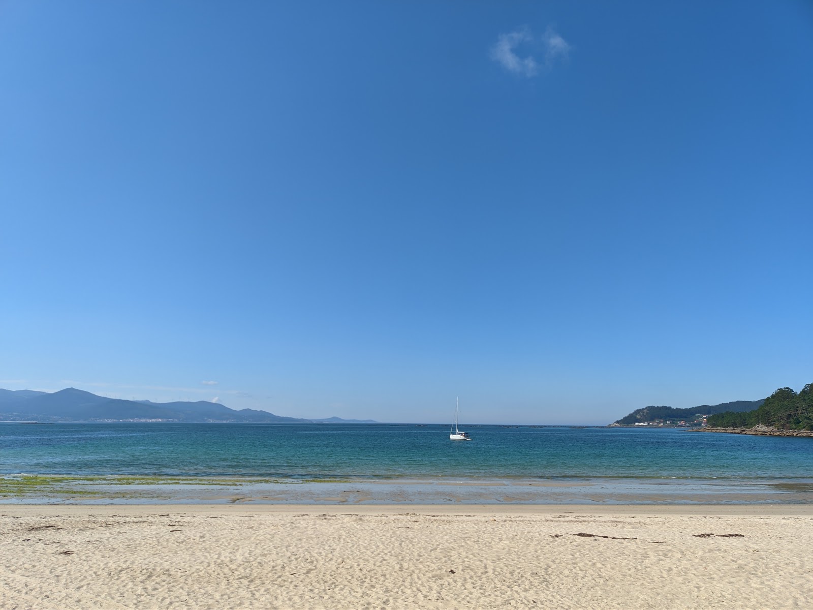 Photo of Praia de Ventin with white sand surface