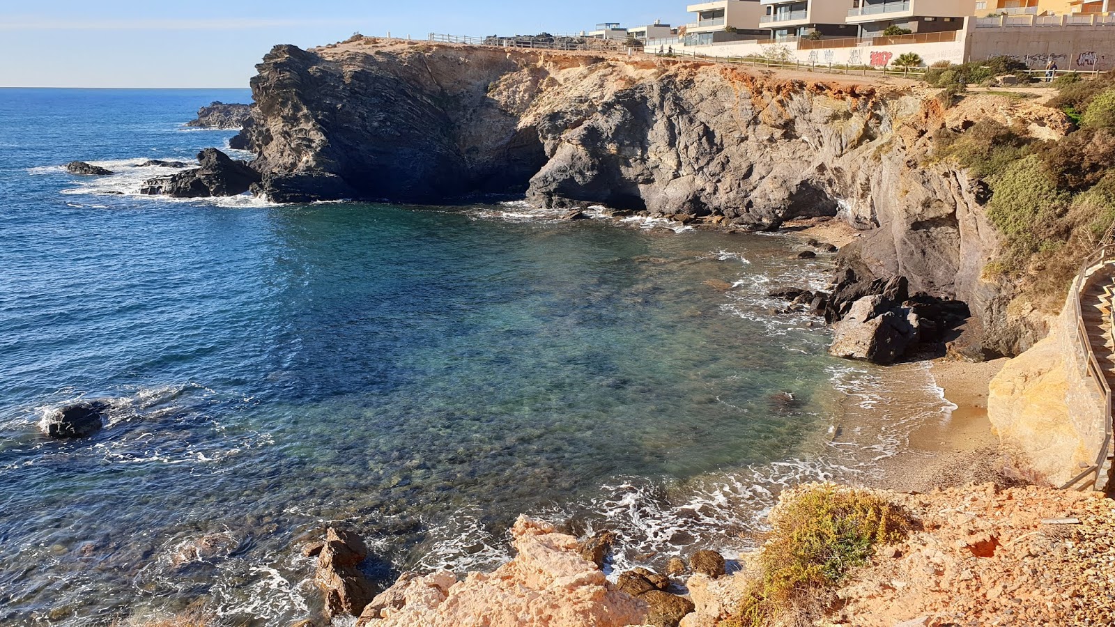 Fotografija Playa de Paseo Acantilado z harmaa hiekka ja kivi površino