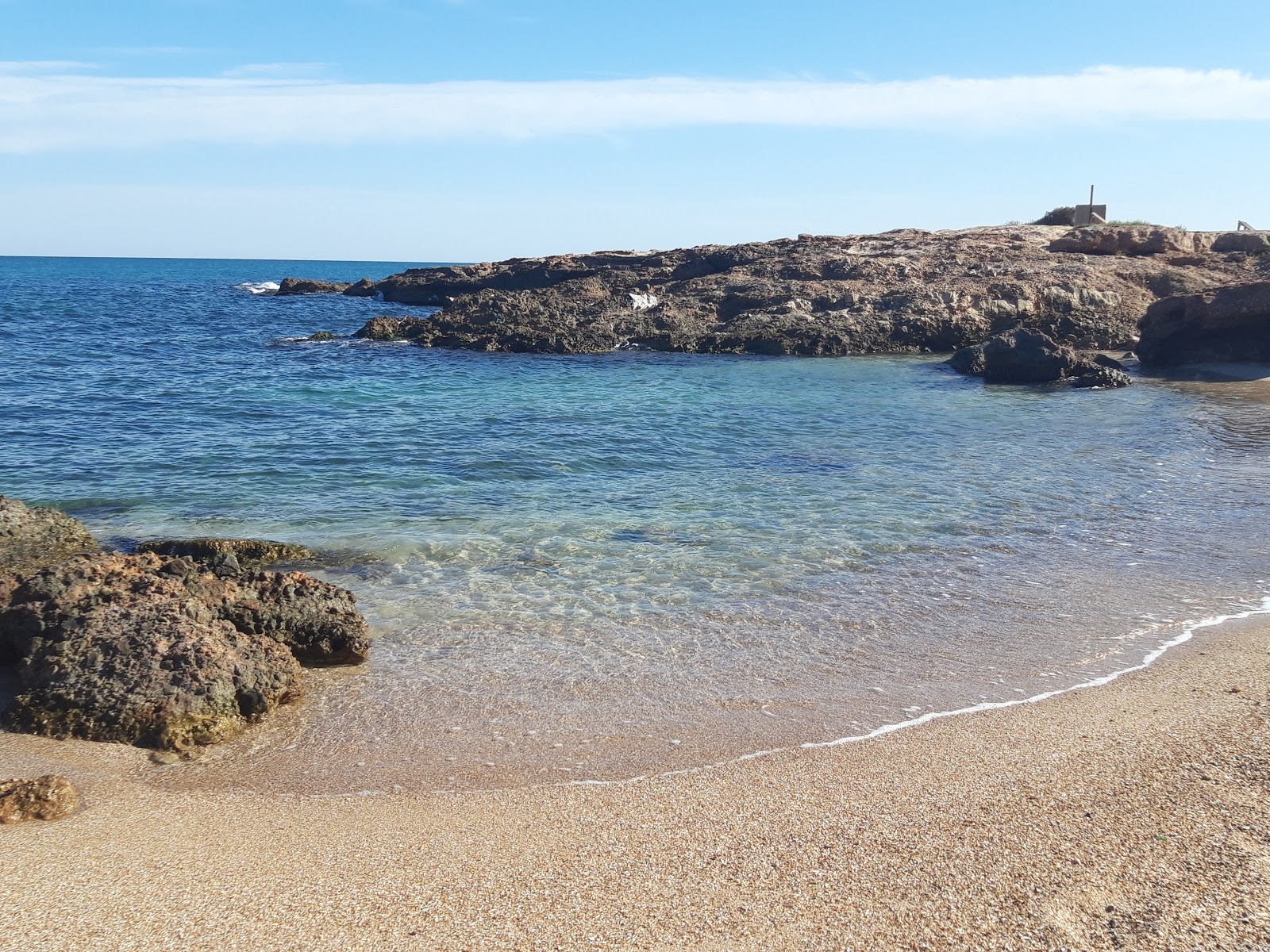 Foto av Cala del Moro med grönt vatten yta