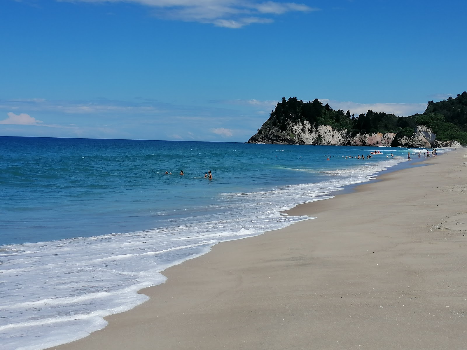 Fotografie cu Whiritoa Beach cu o suprafață de nisip strălucitor