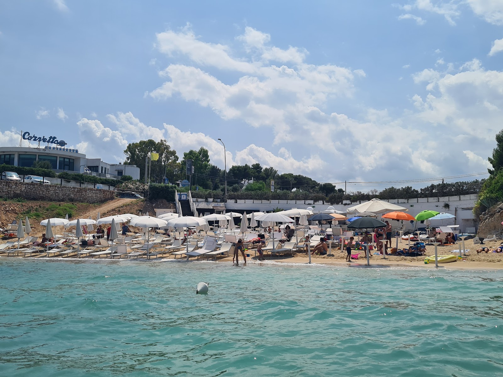 Porto Giardino Beach'in fotoğrafı mavi saf su yüzey ile