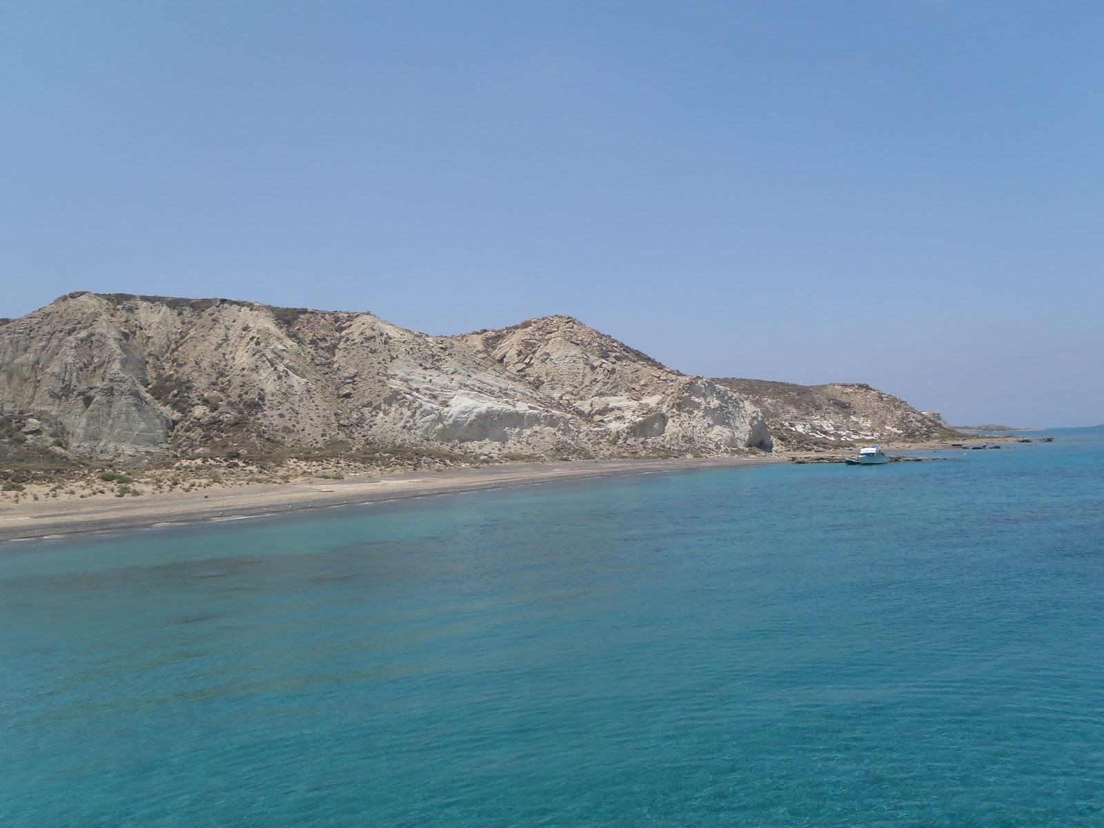 Fotografie cu Grey beach cu o suprafață de apa pură turcoaz