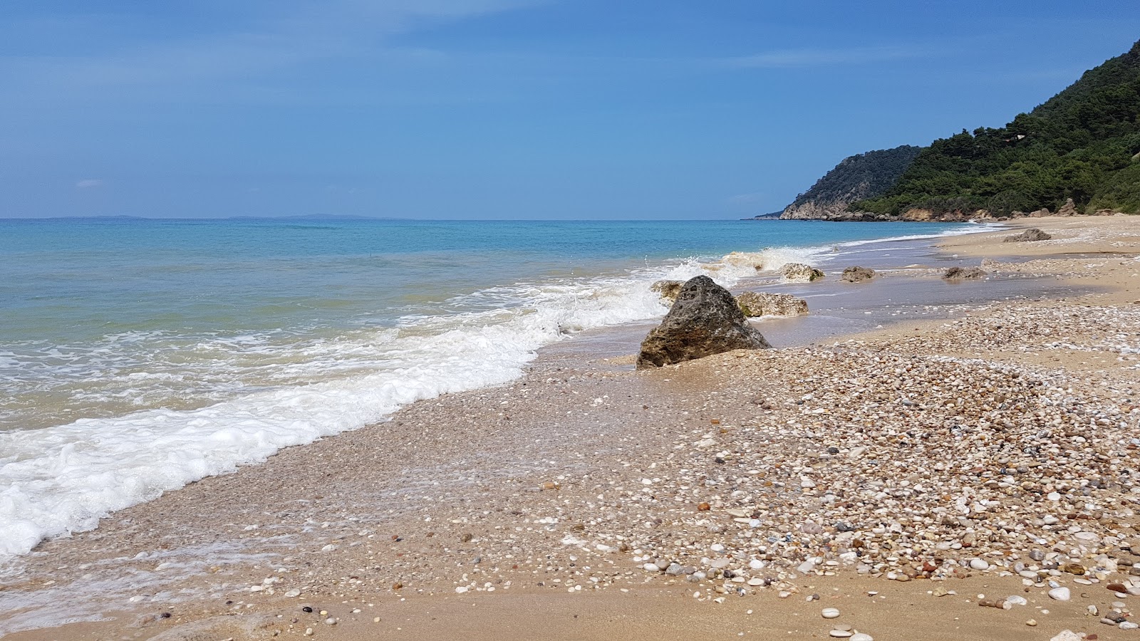 Fotografija loutsas beach z zelena čista voda površino