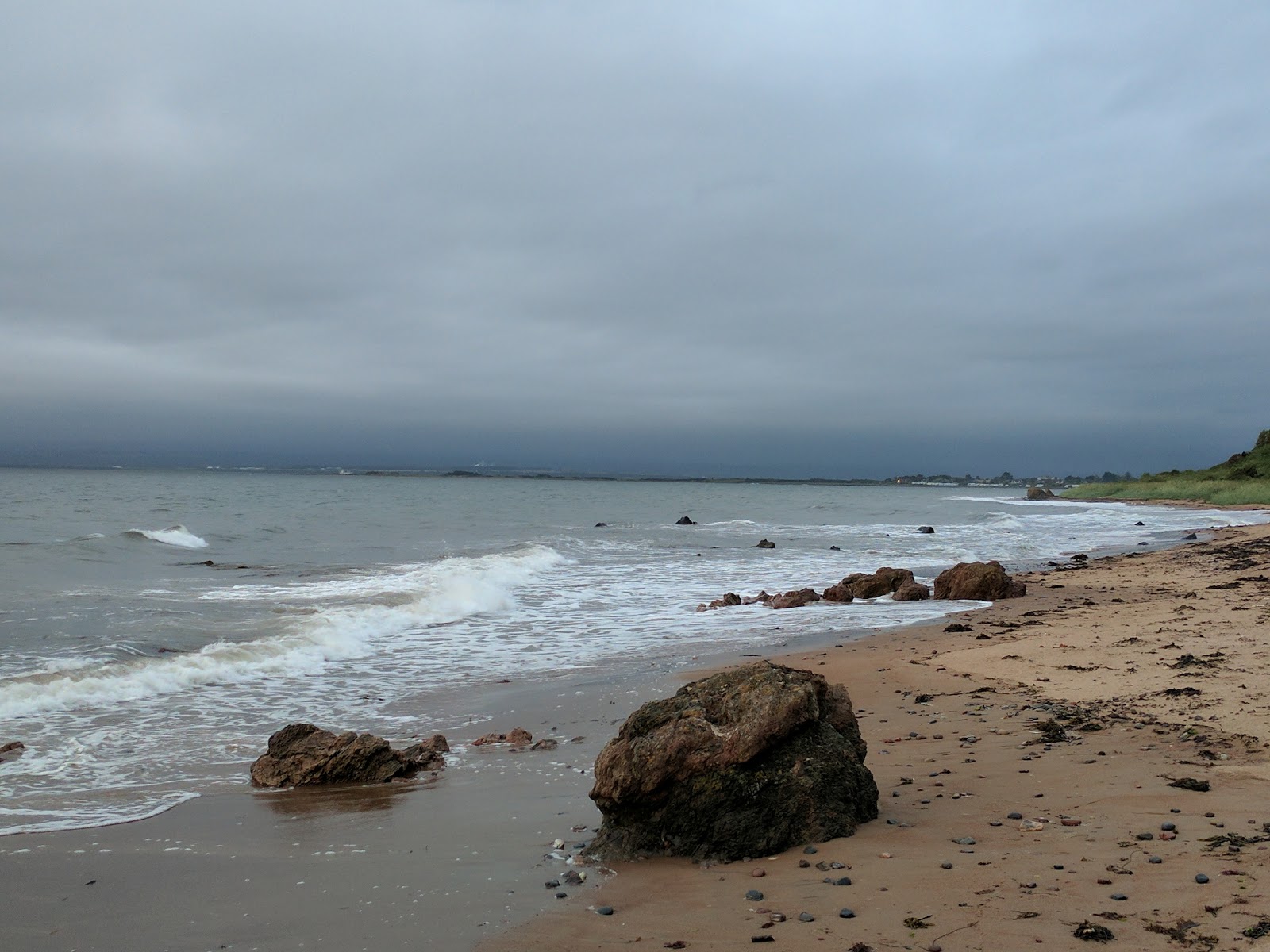 Rosemarkie Beach Caves的照片 带有碧绿色纯水表面