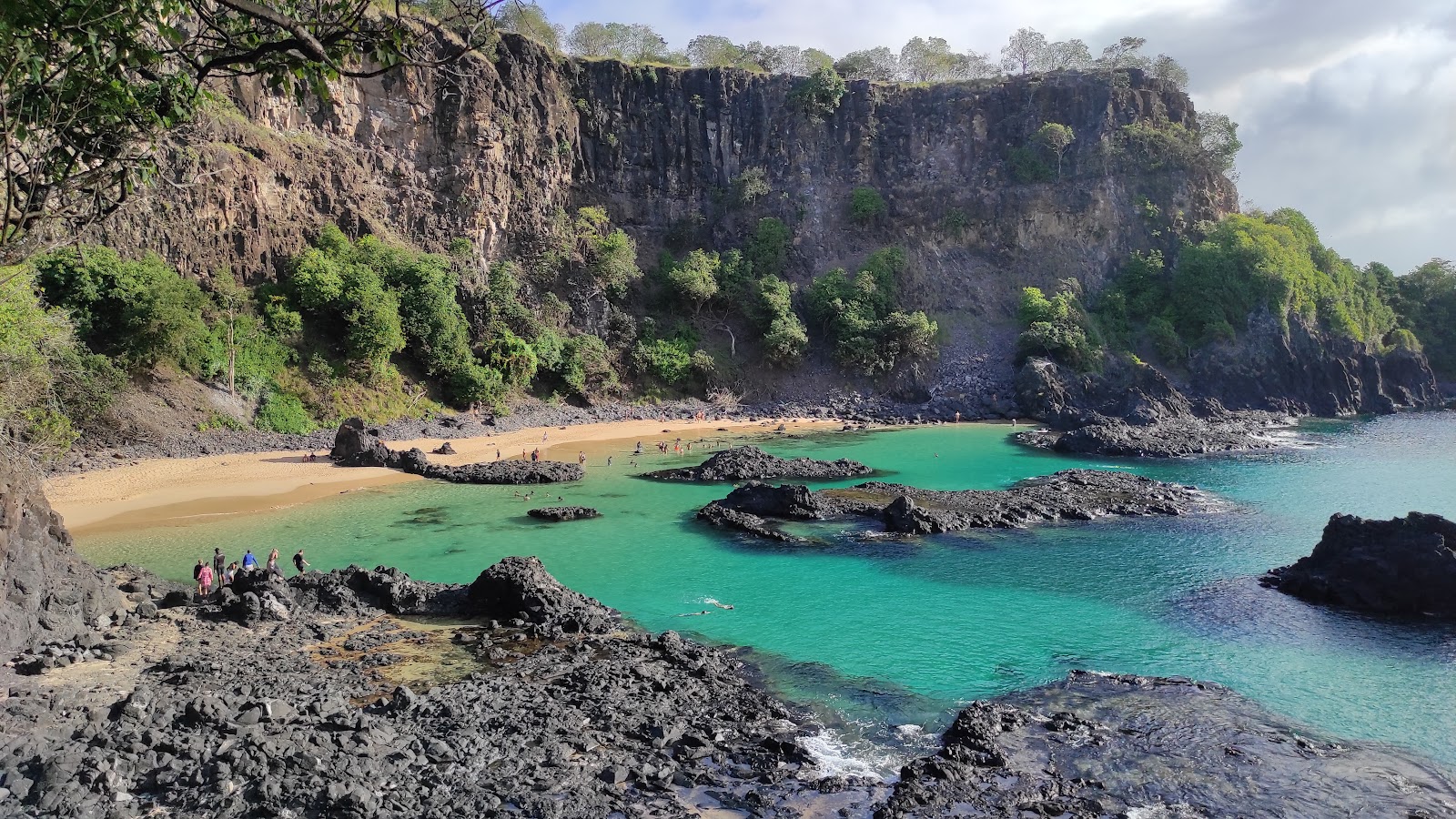 Foto di Baia dos Porcos con una superficie del sabbia beige e rocce