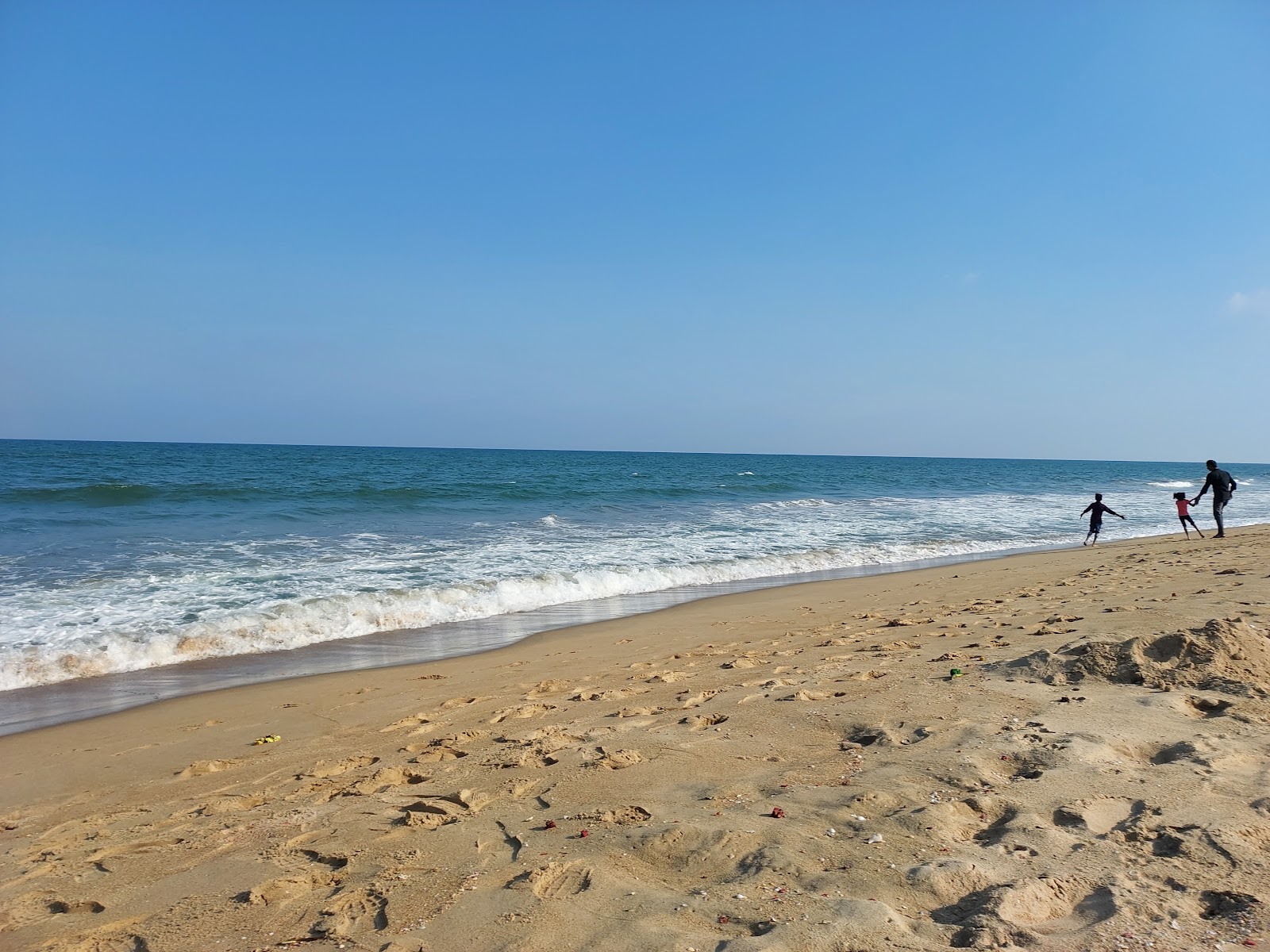 Foto av Golden Beach med lång rak strand
