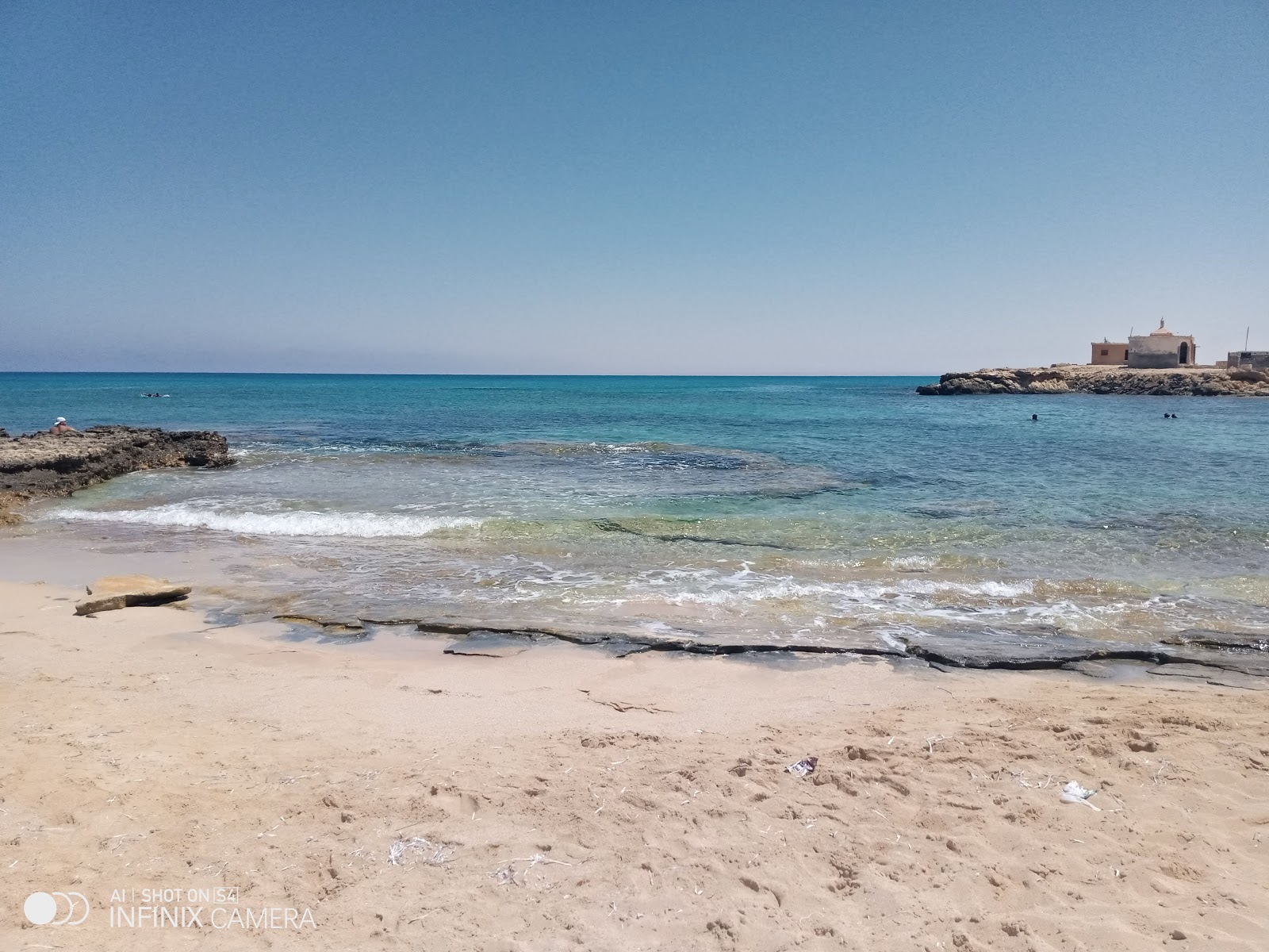 Valokuva Alam El Roum Beachista. pinnalla kirkas hiekka:n kanssa