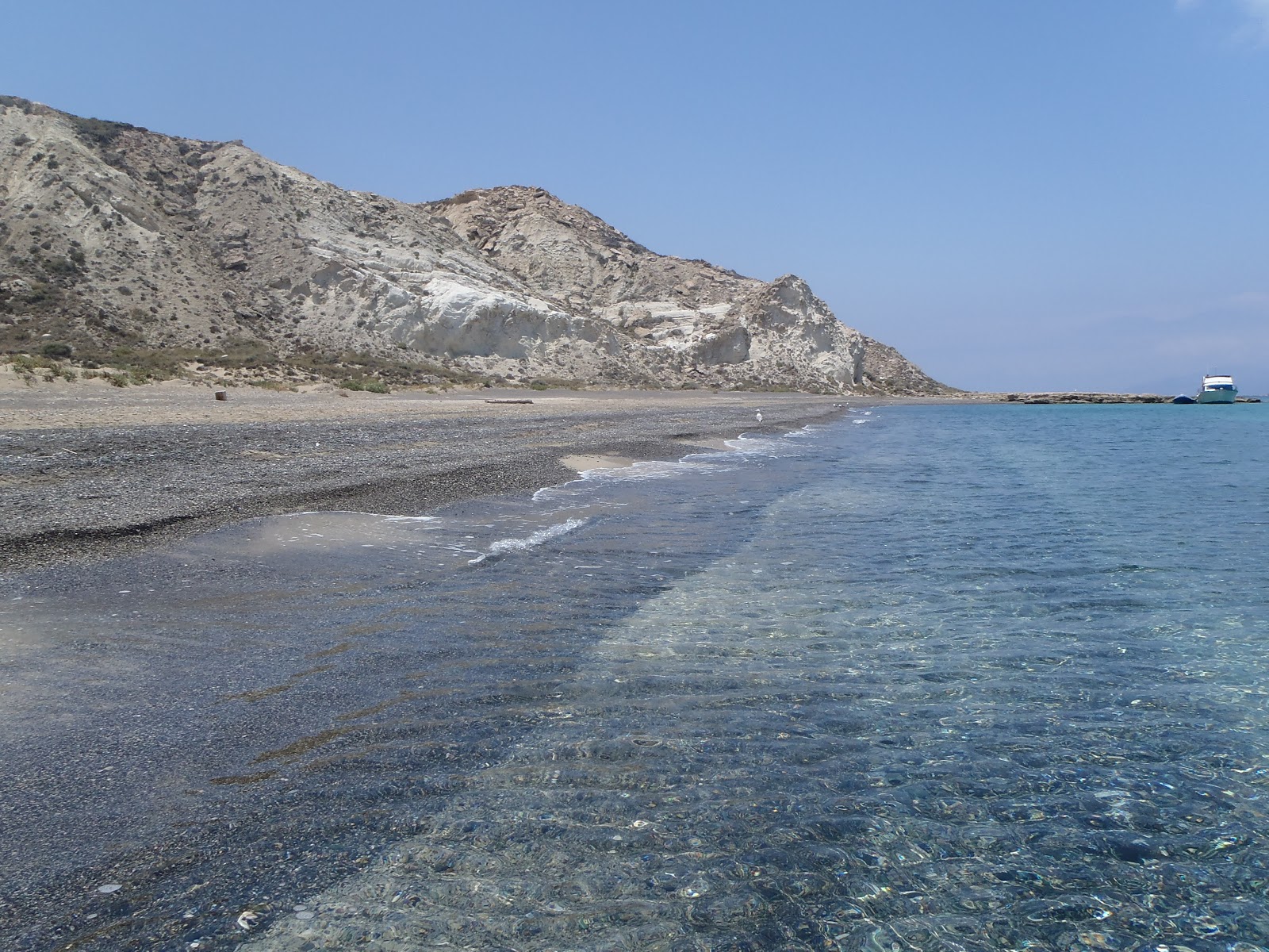 Fotografie cu Grey beach cu o suprafață de nisip gri și pietricel