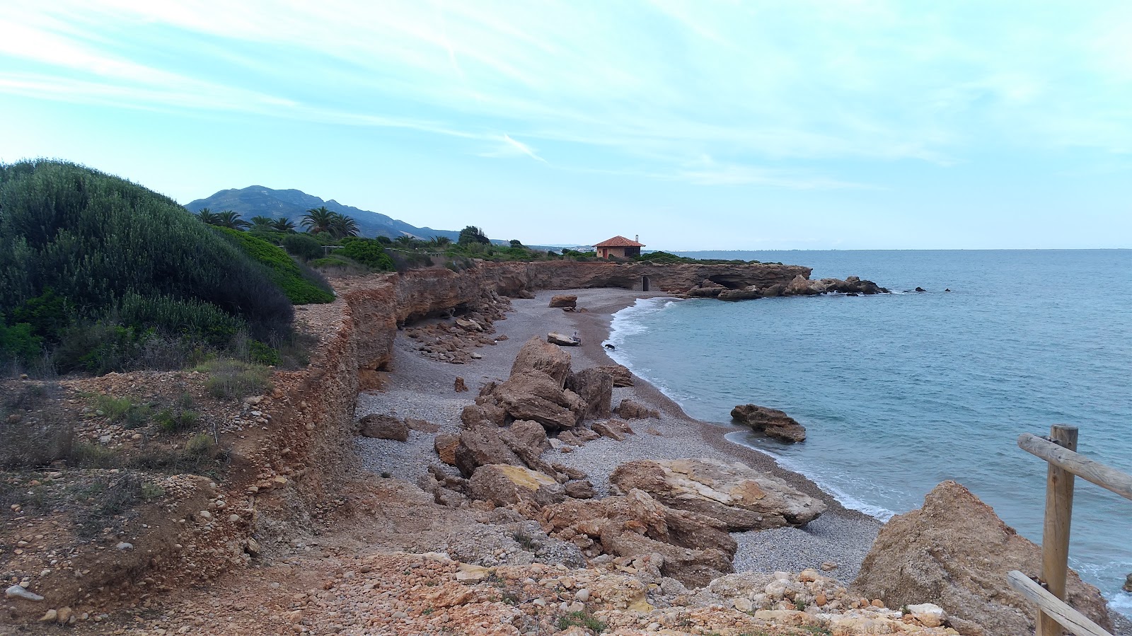 Foto di Cala de la Sunyera con una superficie del piccoli ciottoli beige