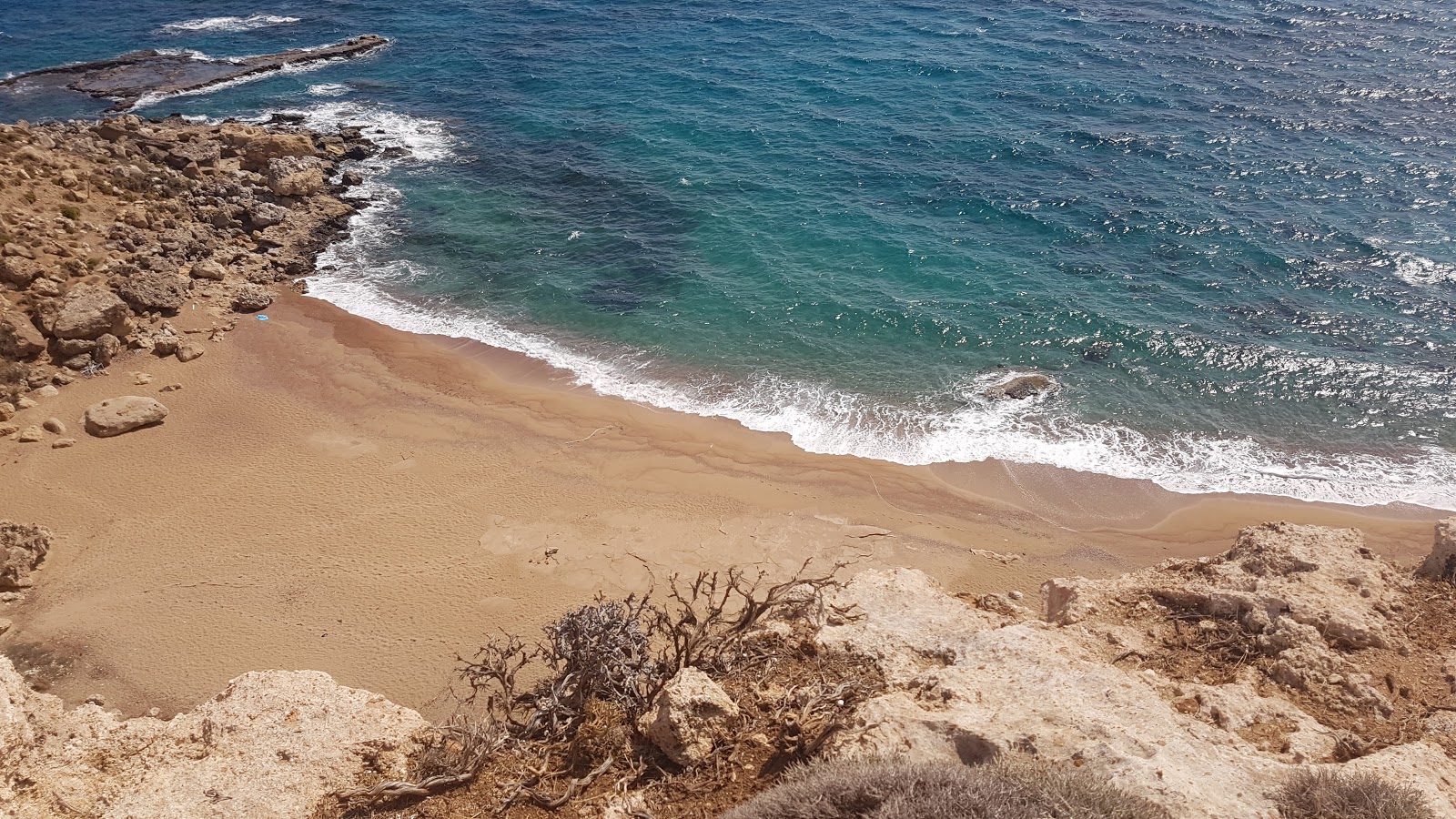 Fotografija Red Sand Beach z turkizna čista voda površino